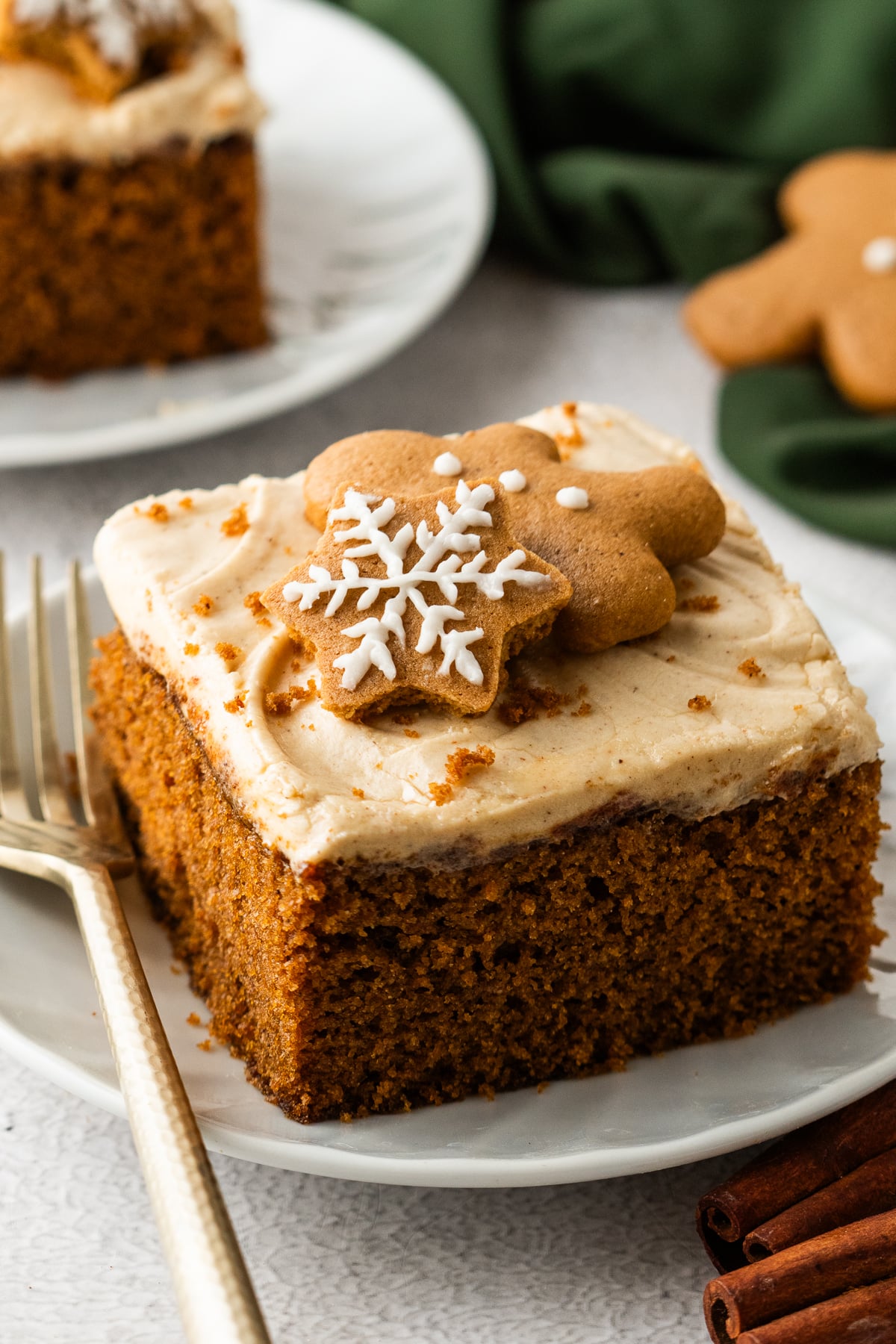 slice of Gingerbread Cake with Cream Cheese Frosting on plates sitting on table with main cake in pan