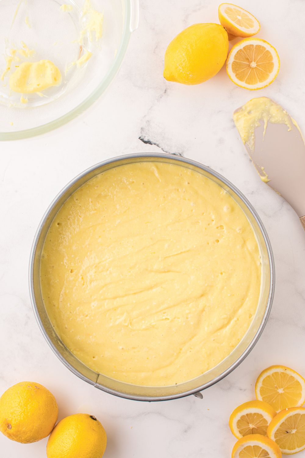 raw cake batter for Lemon Ricotta Cake in a round pan on table 
