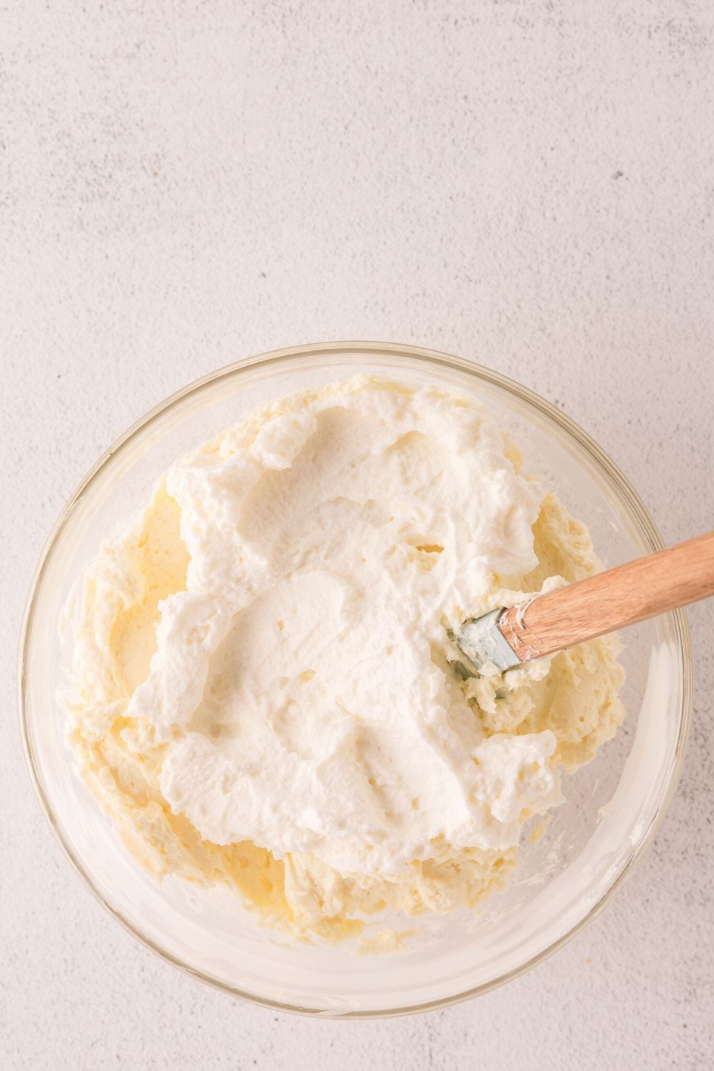 glass bowl with cheesecake batter being mixed in bowl