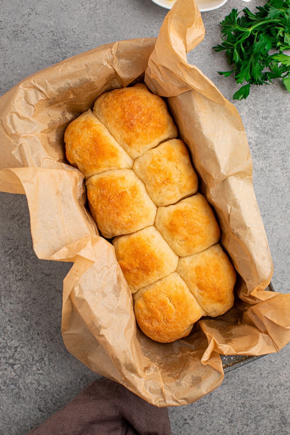 dinner rolls in pan with parchment paper sitting on table