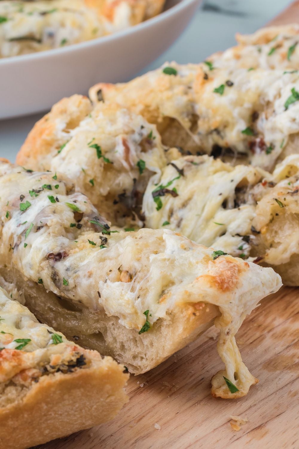 close up of Cheesy Garlic Bread on table to see melted cheese on top of bread