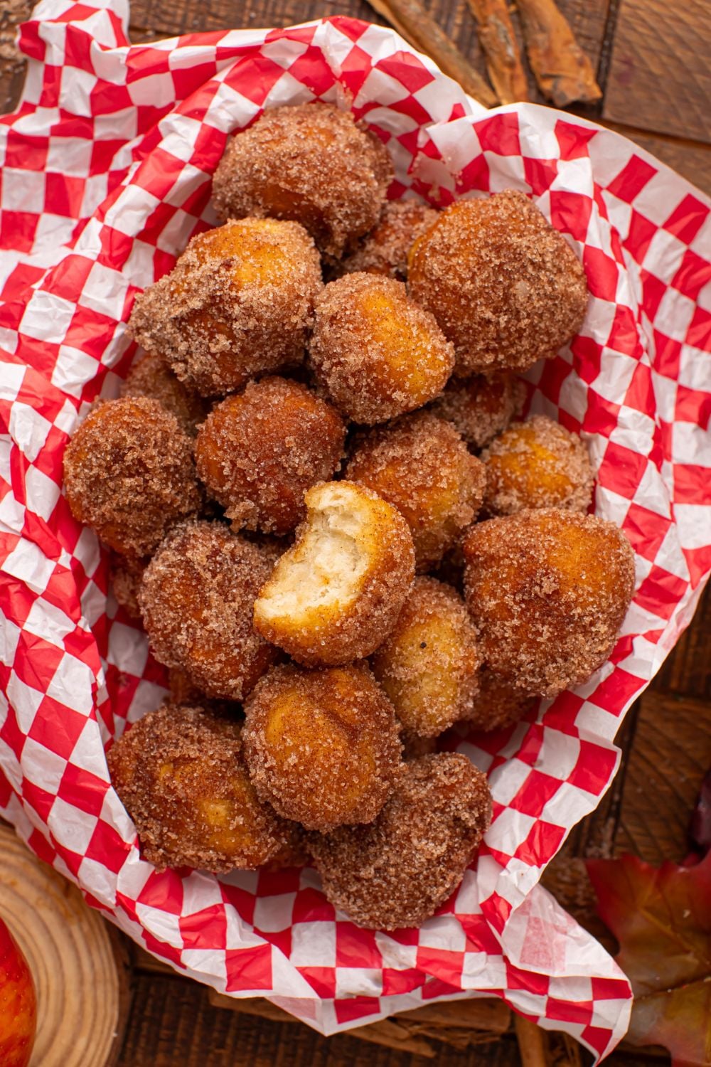 wooden table with a basket full of Apple Pie Donut Holes inside 