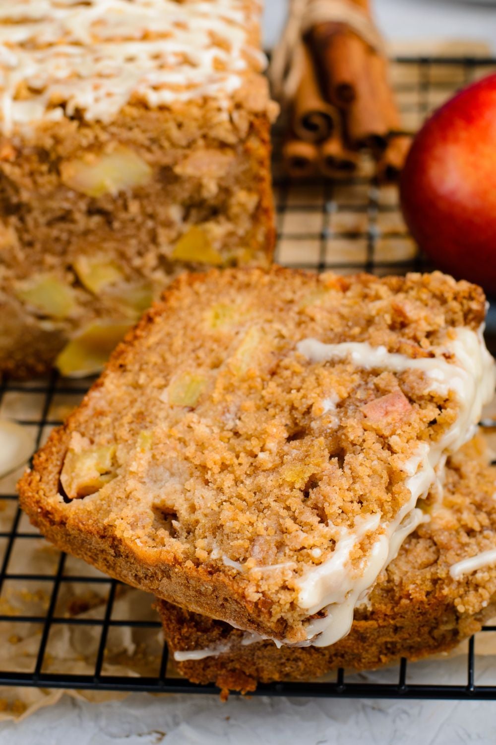 Apple Cinnamon Loaf Cake sliced and placed in a stack on table with a sweet glae drizzled on top