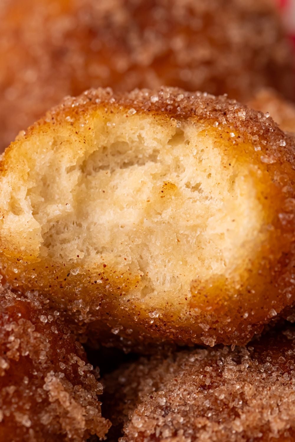 bite taken out of an apple donut hole stacked up on more donut holes