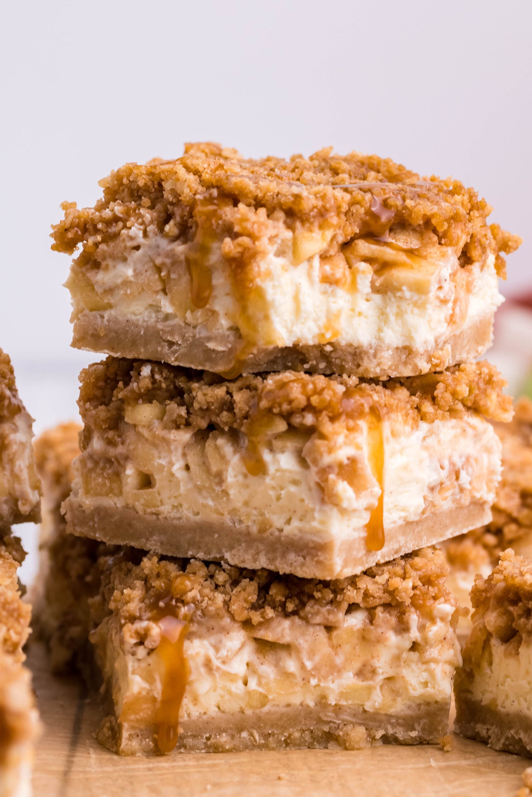 Stack of three Caramel Apple Cheesecake Bars sliced on a table 