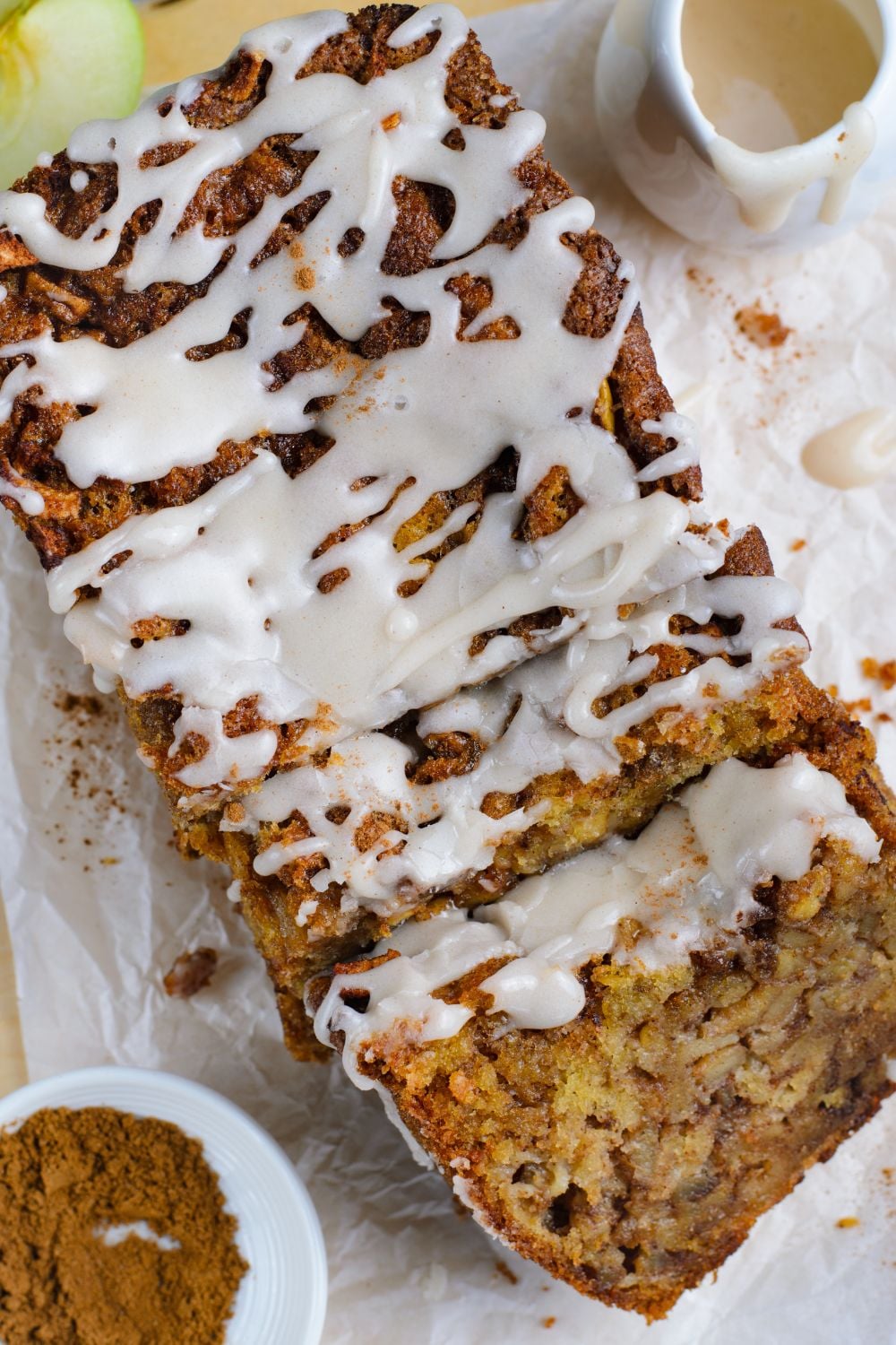 Amish Apple Fritter Bread sliced and laid out on table with a bowl of cinnamon sugar mixture to side