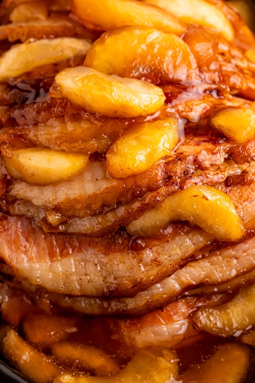 close up look of a cooked spiral cut ham with apple pie filling on top