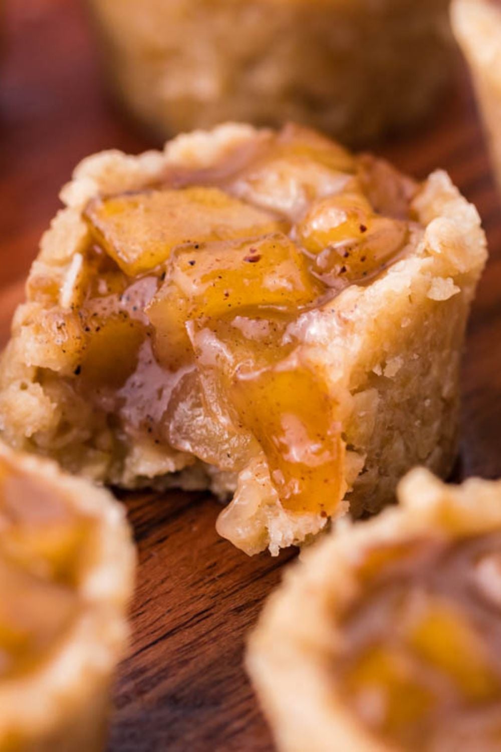 Mini Apple Crisp Bites on table and the one in the center has a bite taken out of it