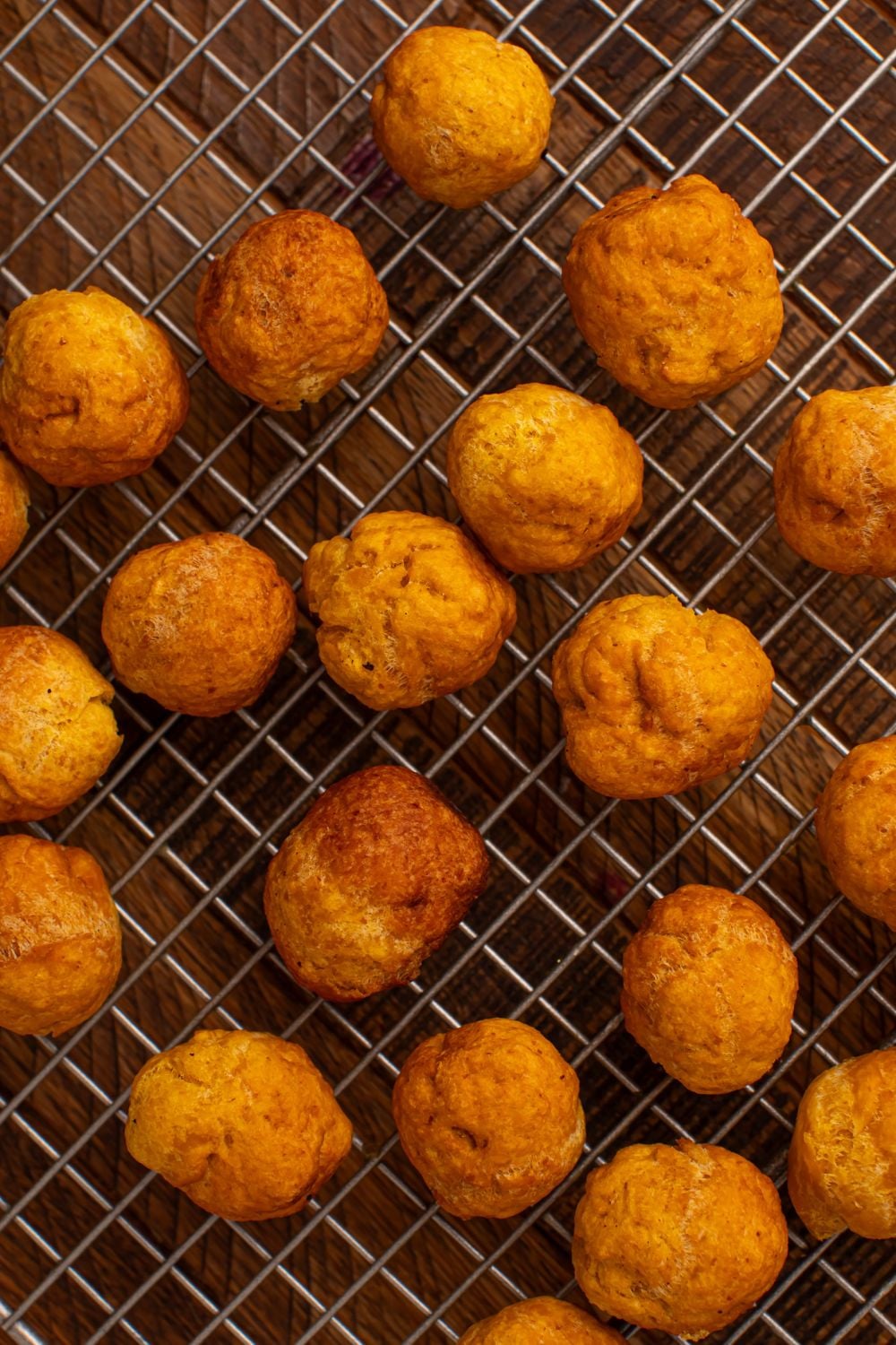 wire tray with a bunch of fried Pumpkin Pie Donut Holes