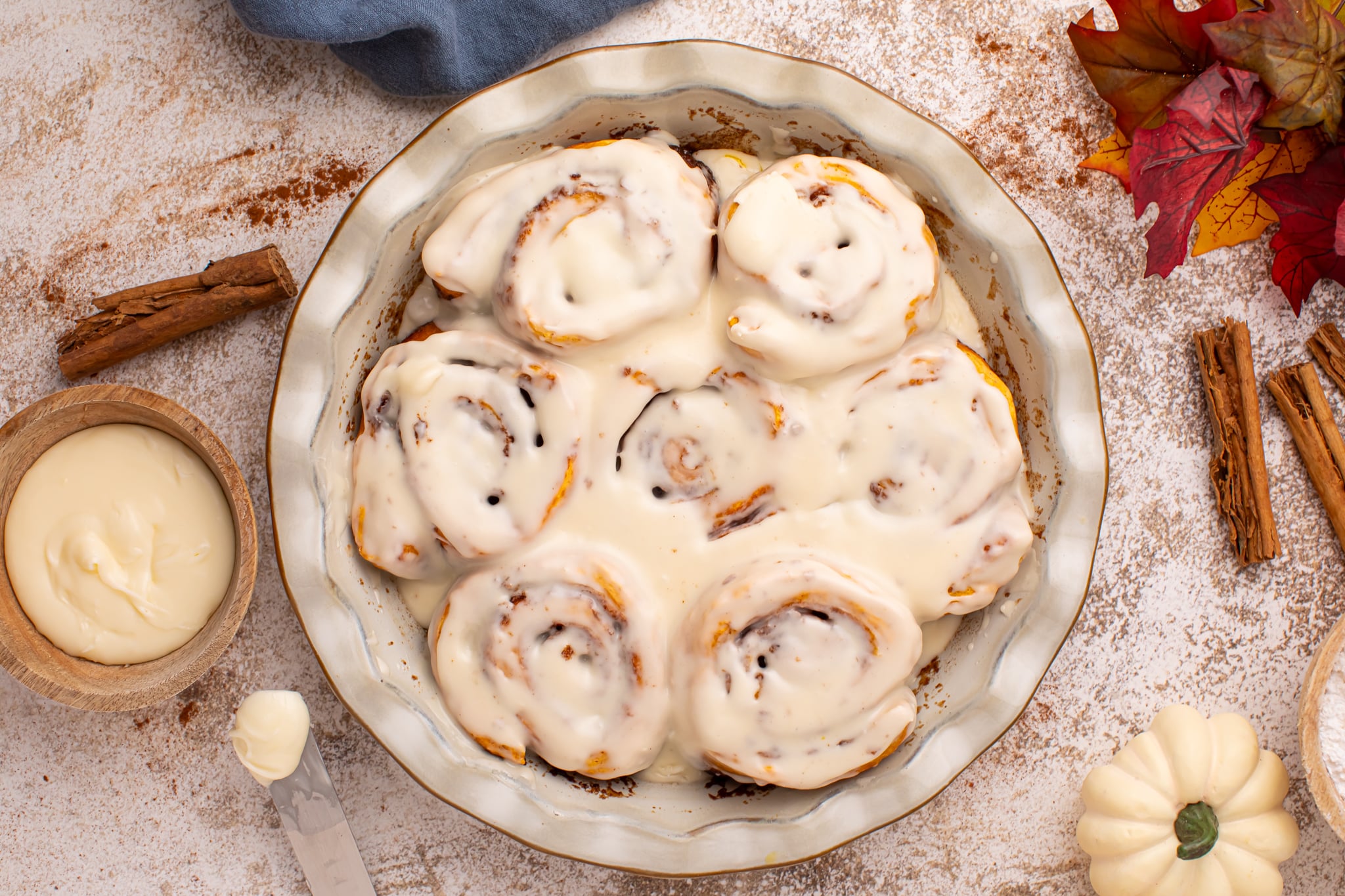Overhead shot of the Easy 2 Ingredient Pumpkin Cinnamon Rolls in a baking dish smothered in icing 