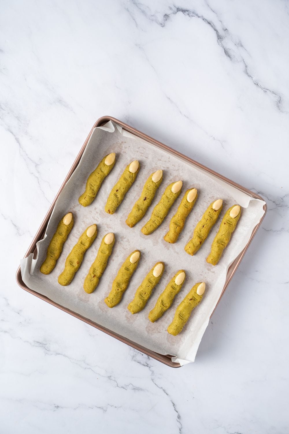 baked Witch Finger Cookies on a baking sheet with parchment paper on the table