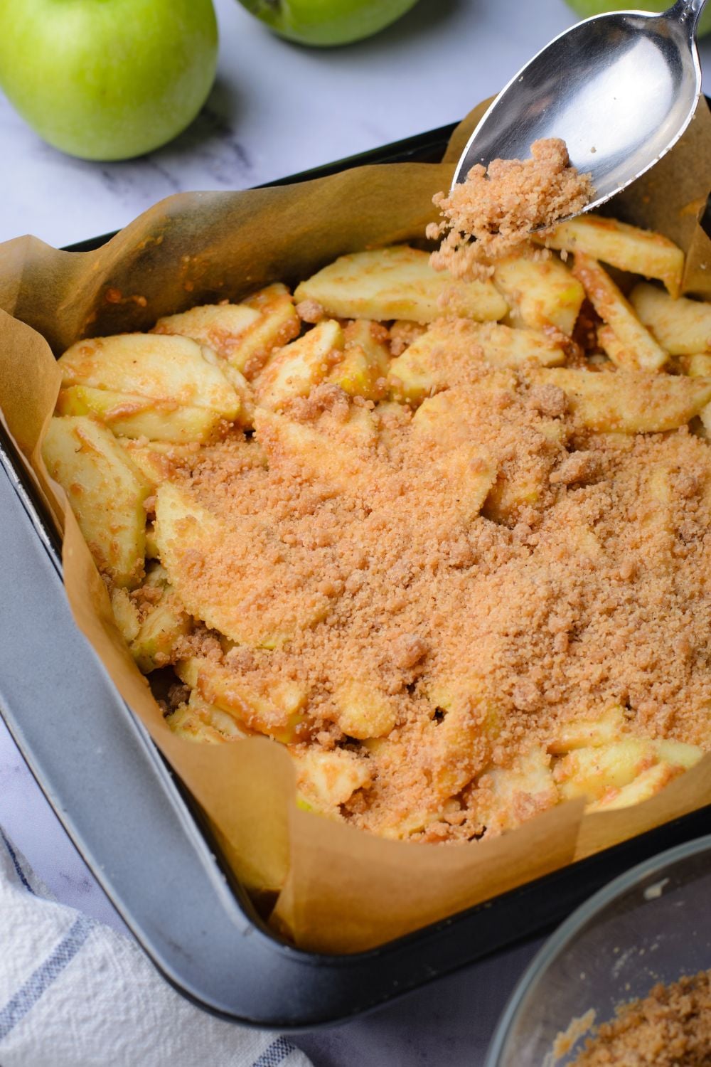 a pan with apples with a crumble topping on top