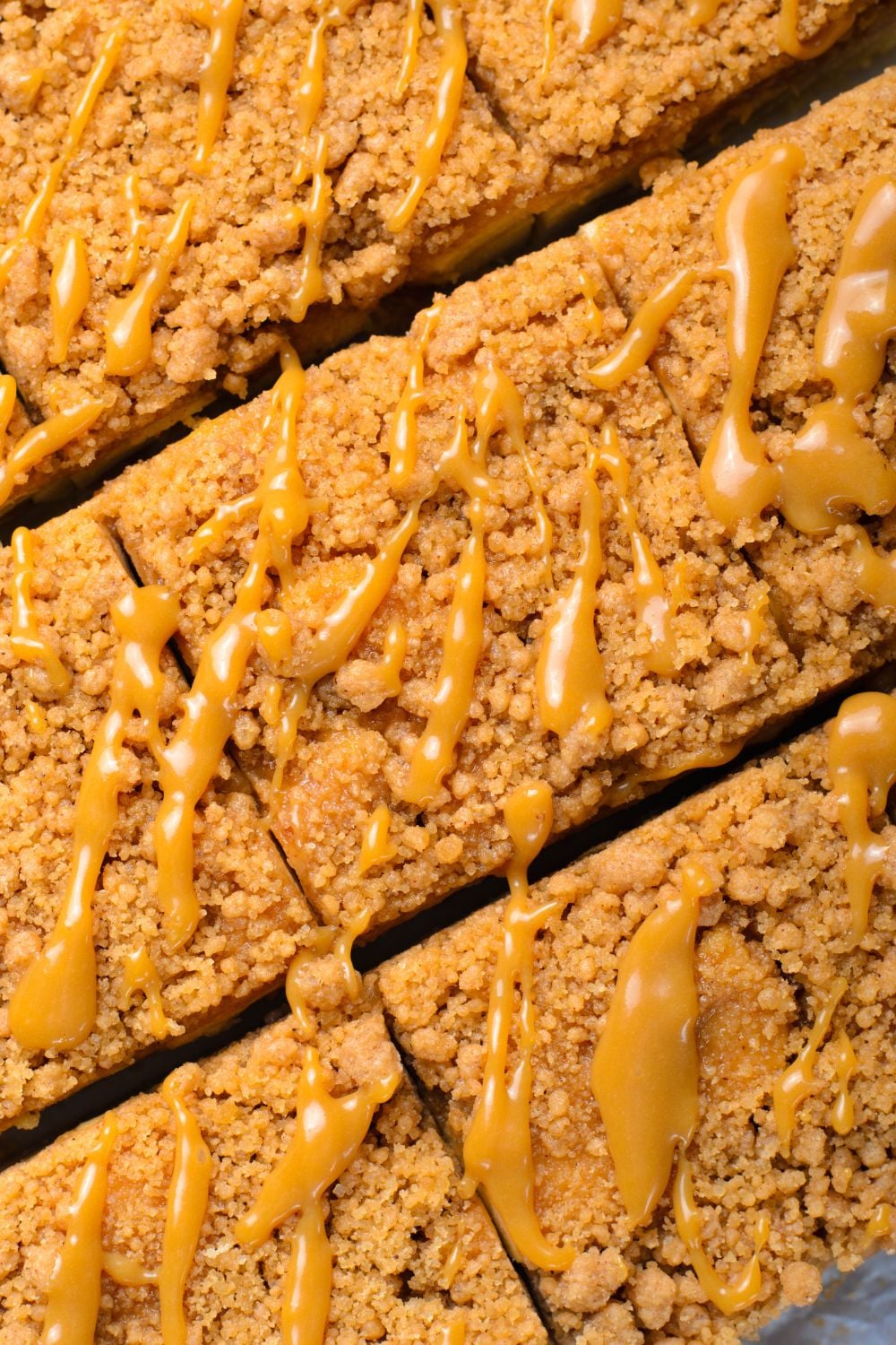 close up to Caramel Apple Pie Bars that are cut into squares drizzled with a bit of caramel