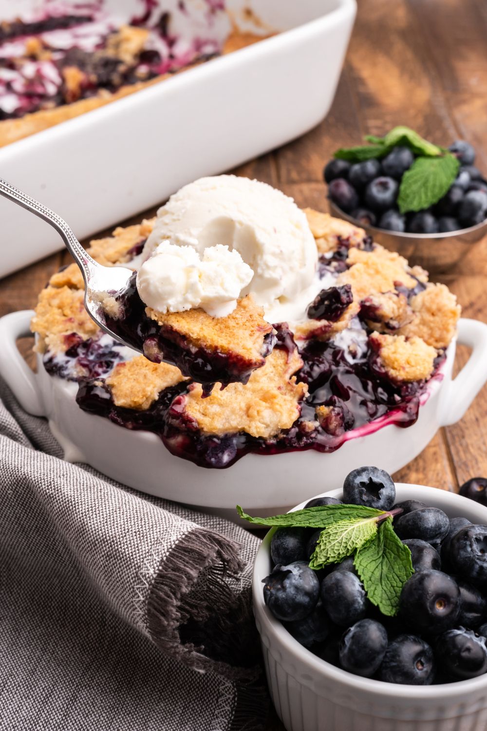 spoon scooping in a bowl with dump cake and ice cream