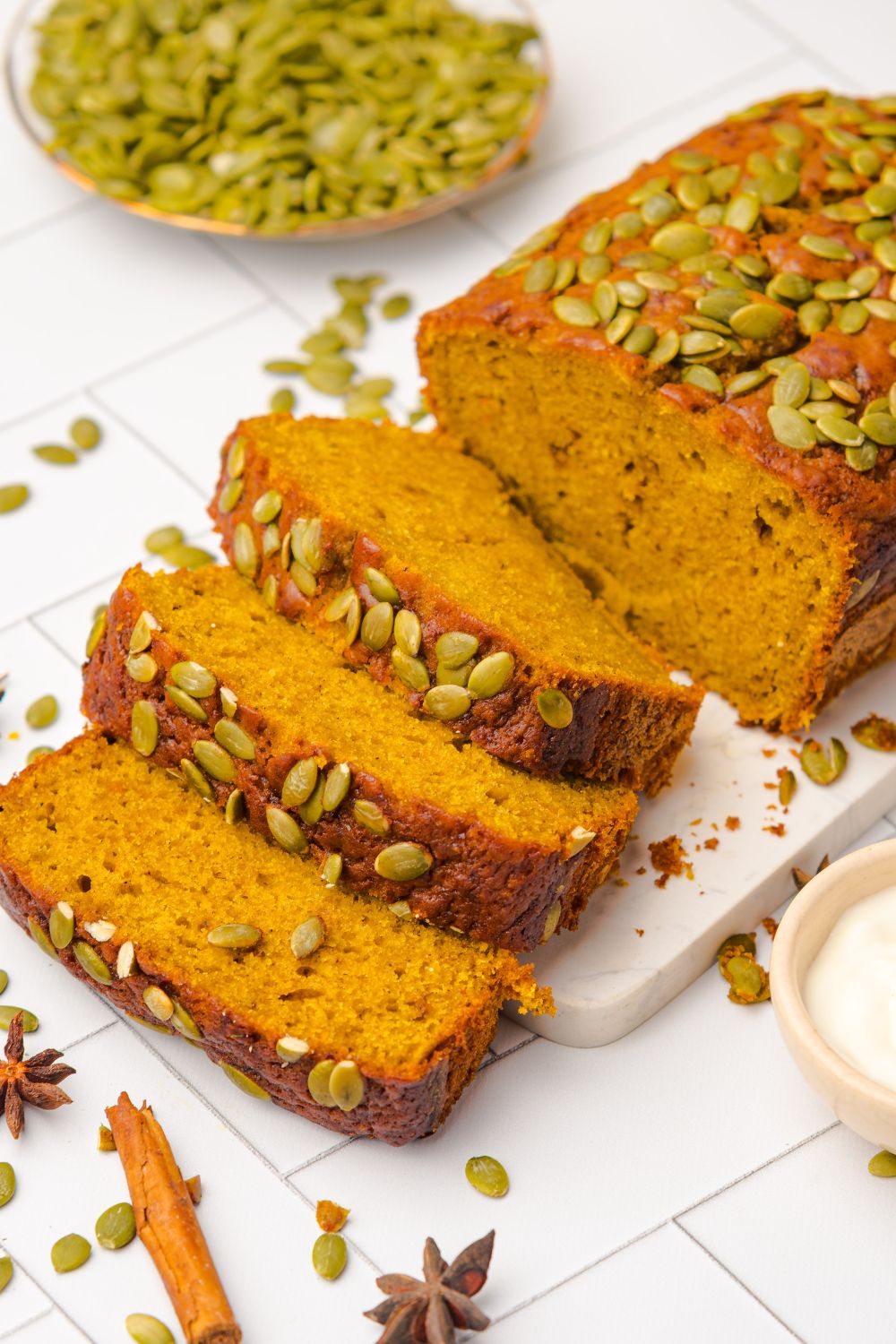 Starbucks Pumpkin Bread on a cutting board, and part of the loaf is sliced into thick slices and laid out on the table