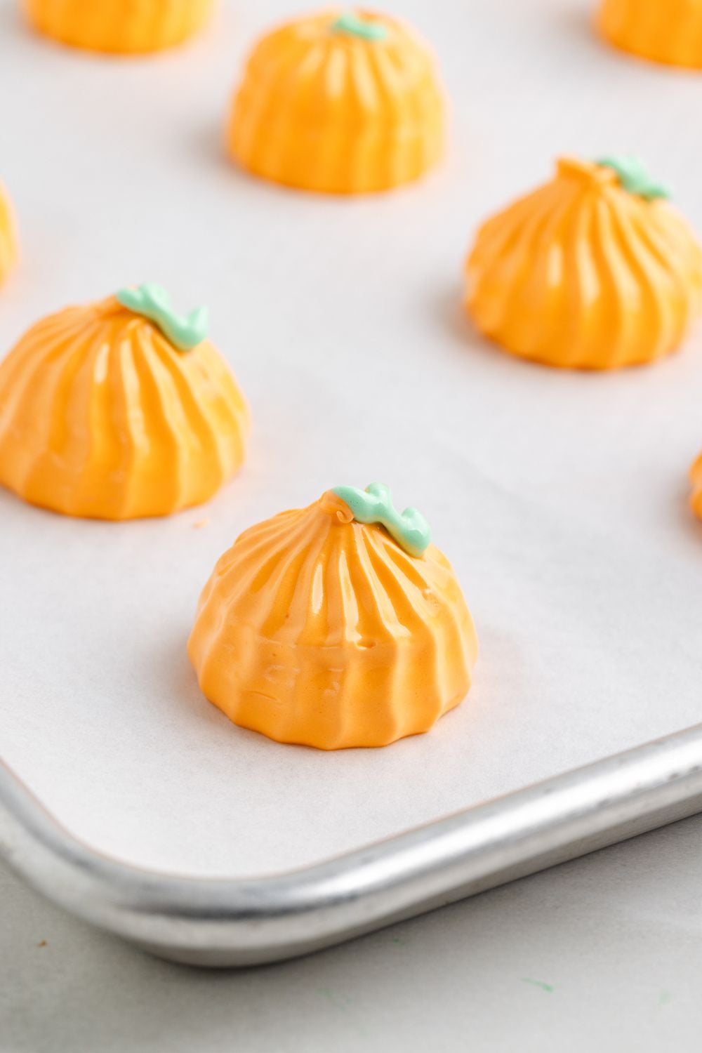 Pumpkin Meringues piped onto a metal baking sheet lined with parchment paper 