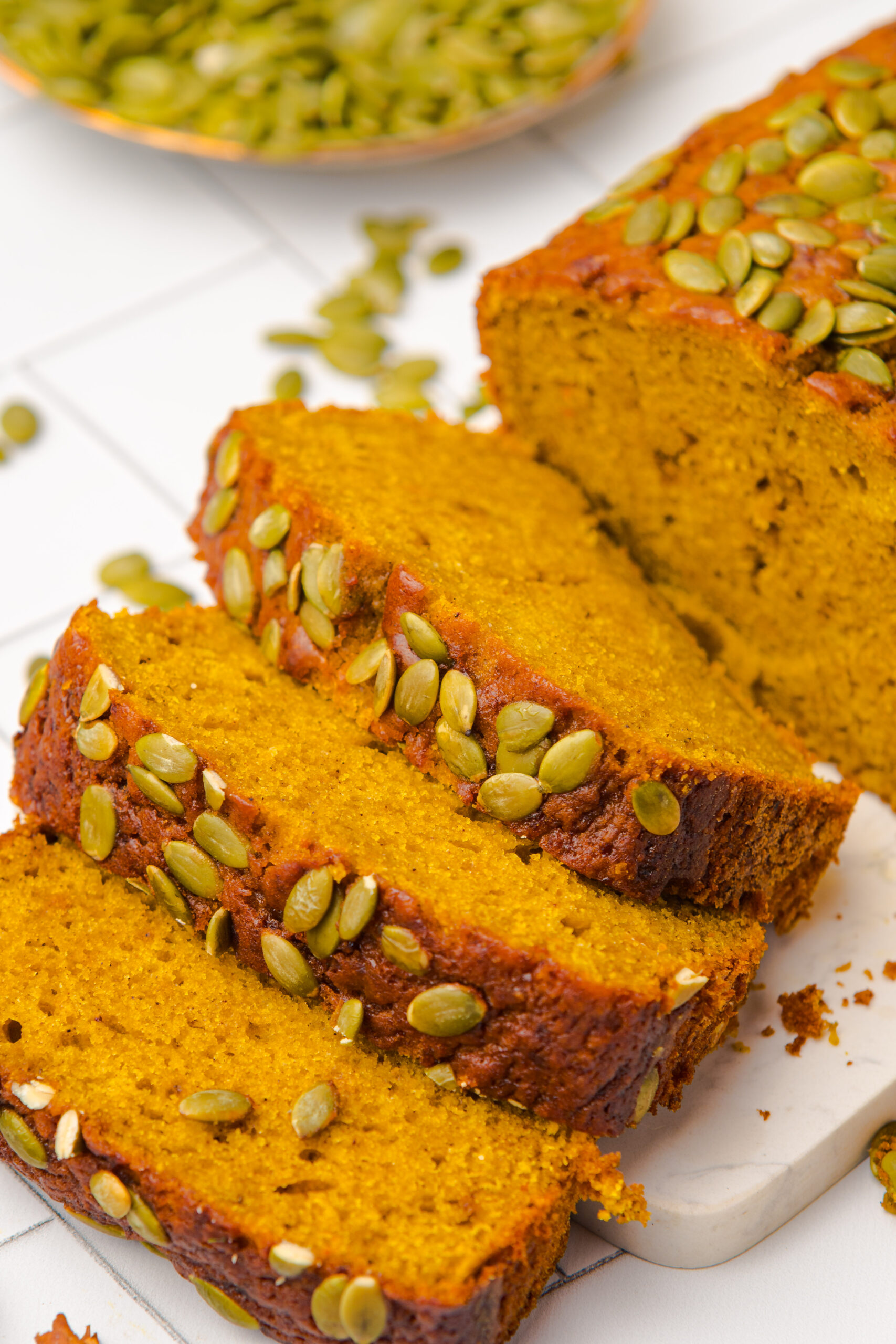 Starbucks Pumpkin Bread sliced and placed on table with pumpkin seeds on top of each loaf