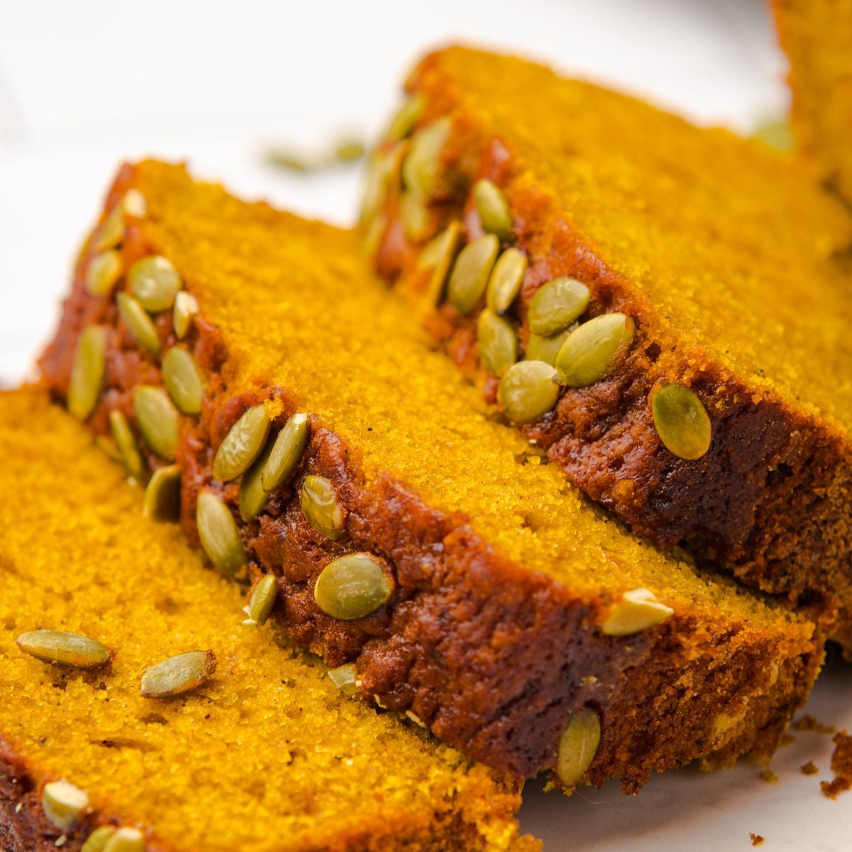 Starbucks Pumpkin Bread sliced and placed on table with pumpkin seeds on top of each loaf