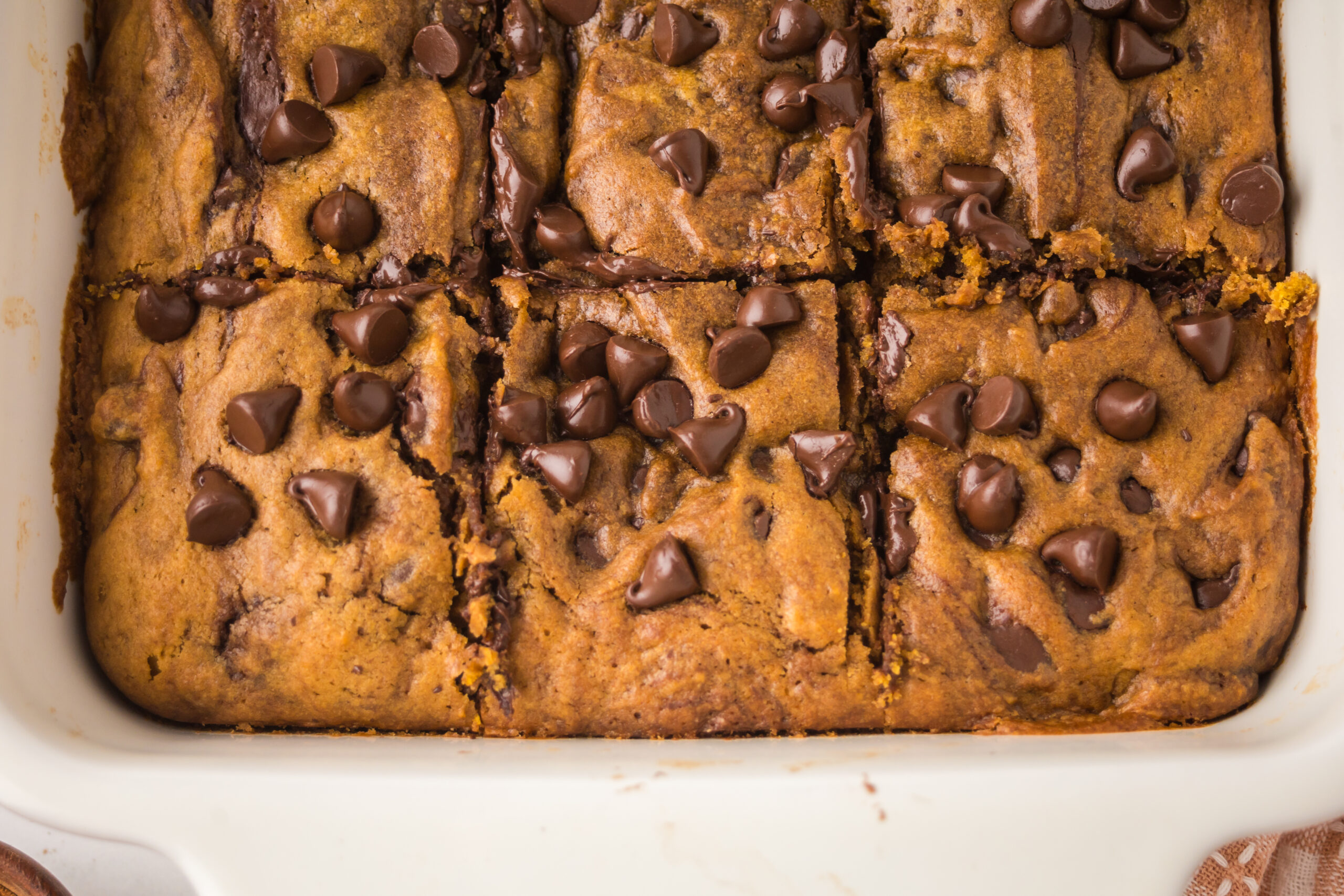 Brown Butter Pumpkin Chocolate Chip Bars in a white baking pan sliced