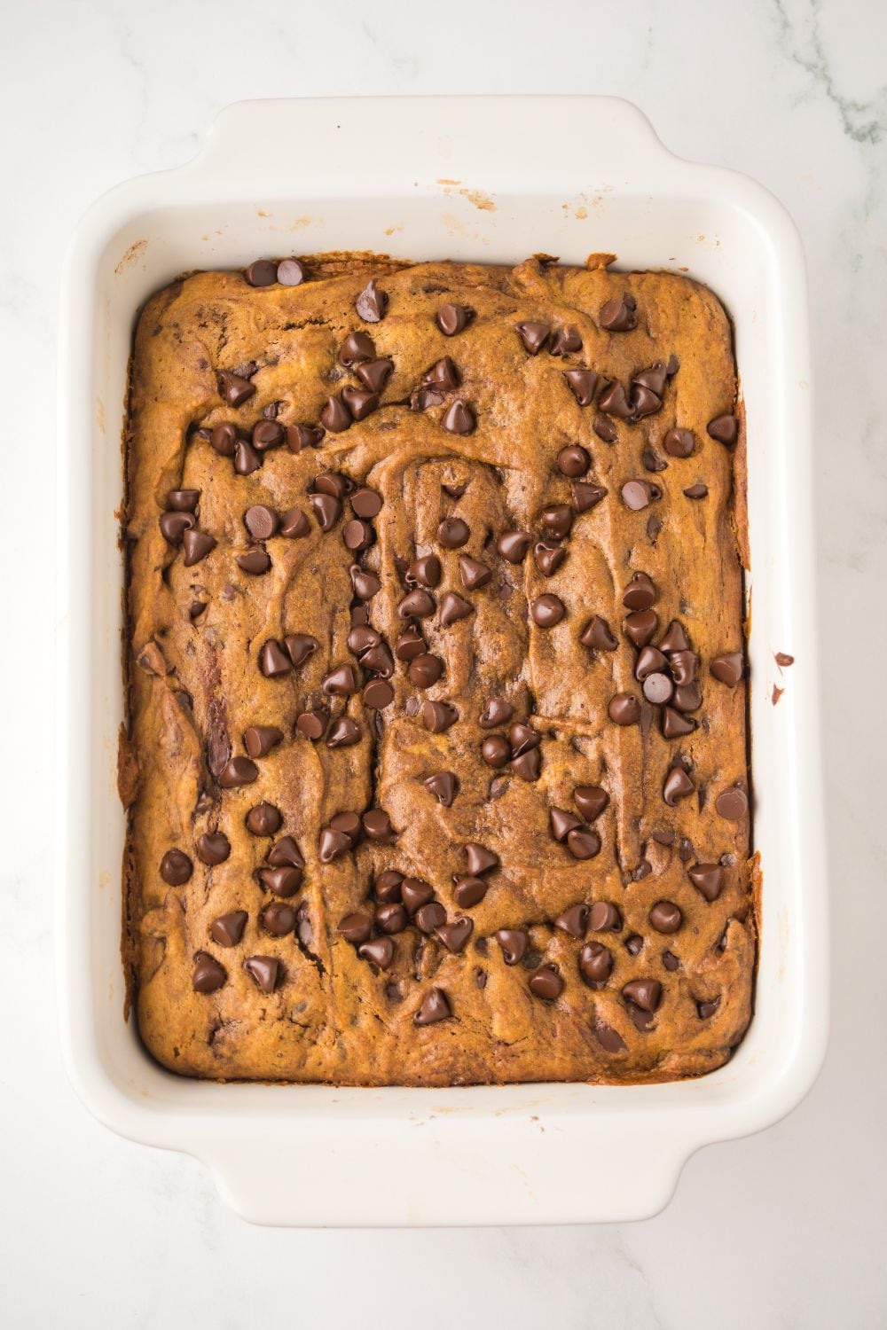 Brown Butter Pumpkin Chocolate Chip Bars in a white pan on table
