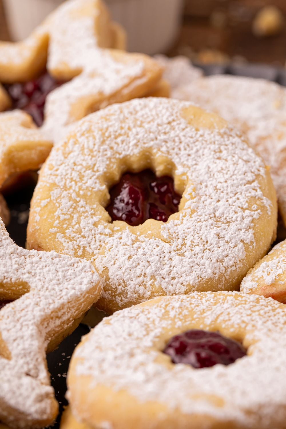 close up of Linzer cookies spread out on table with jam