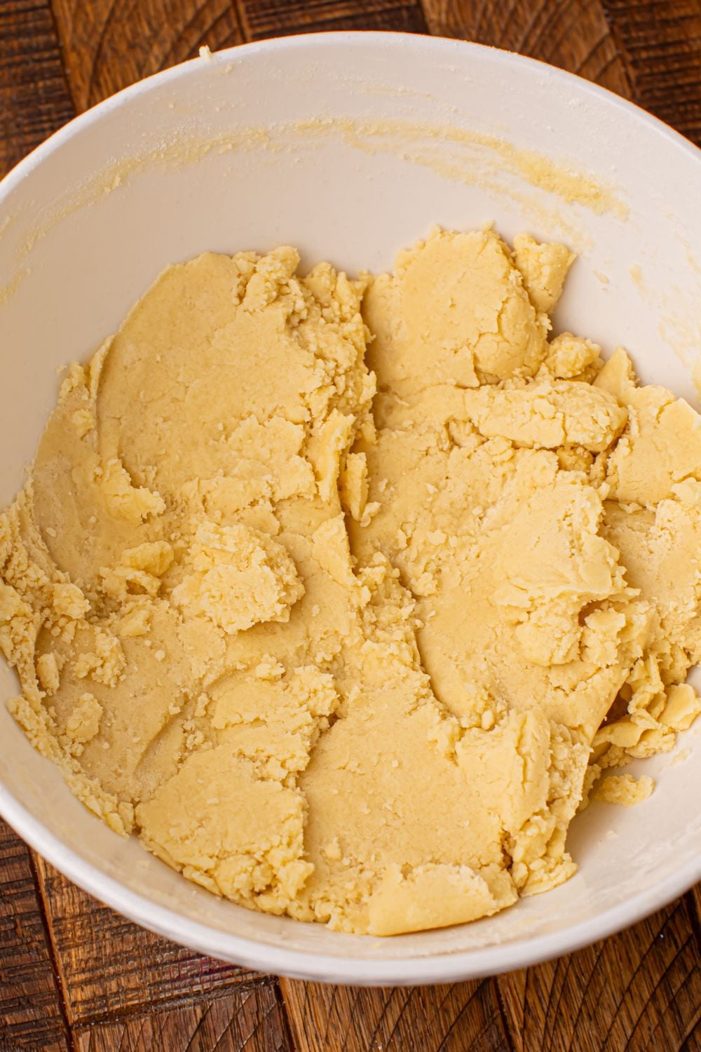 raw cookie dough in a white bowl on wooden table