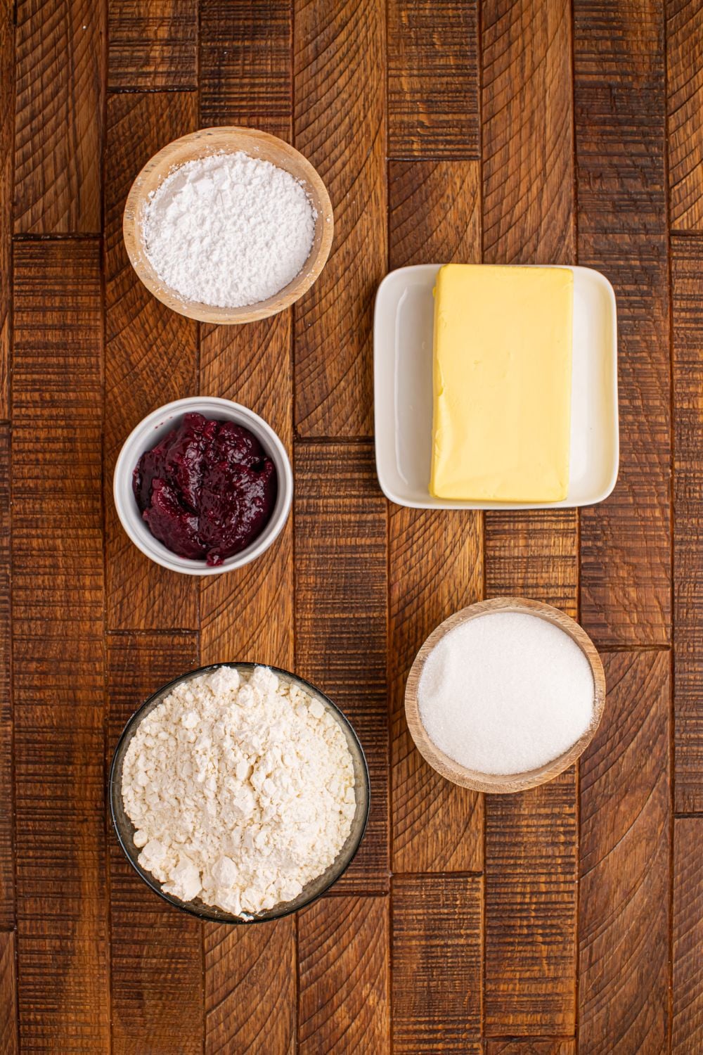 ingredients for making Linzer cookies on a wooden table in single serve containers