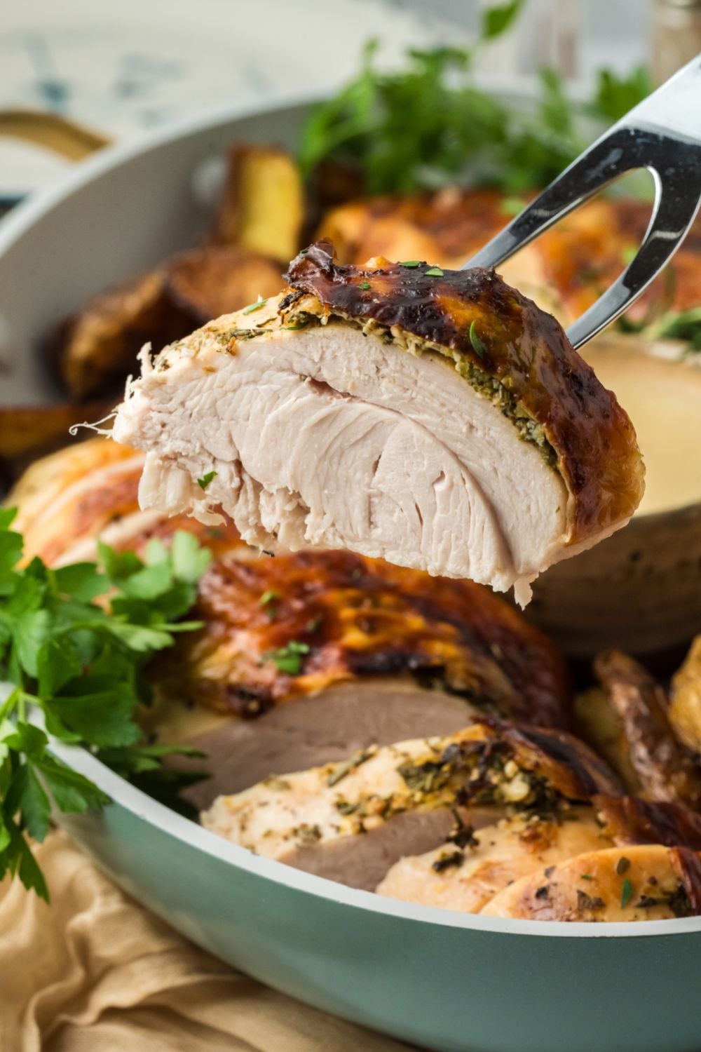 close up look of thick sliced Roasted Turkey Breast in a light teal bowl
