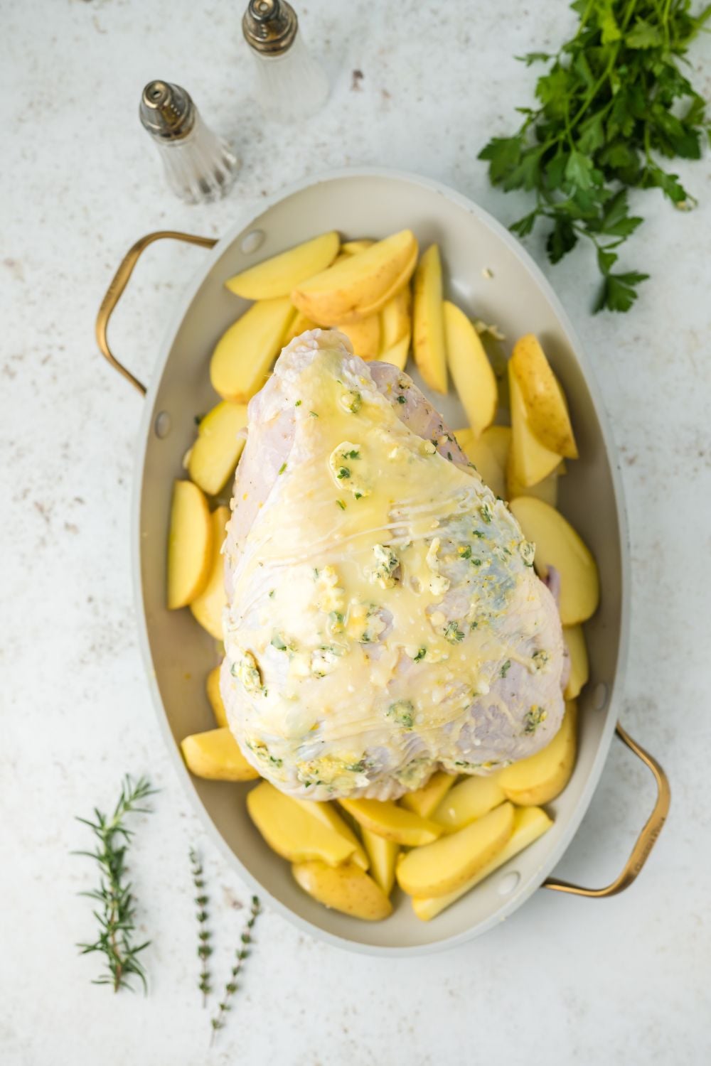 raw turkey breast buttered and seasoned on a platter
