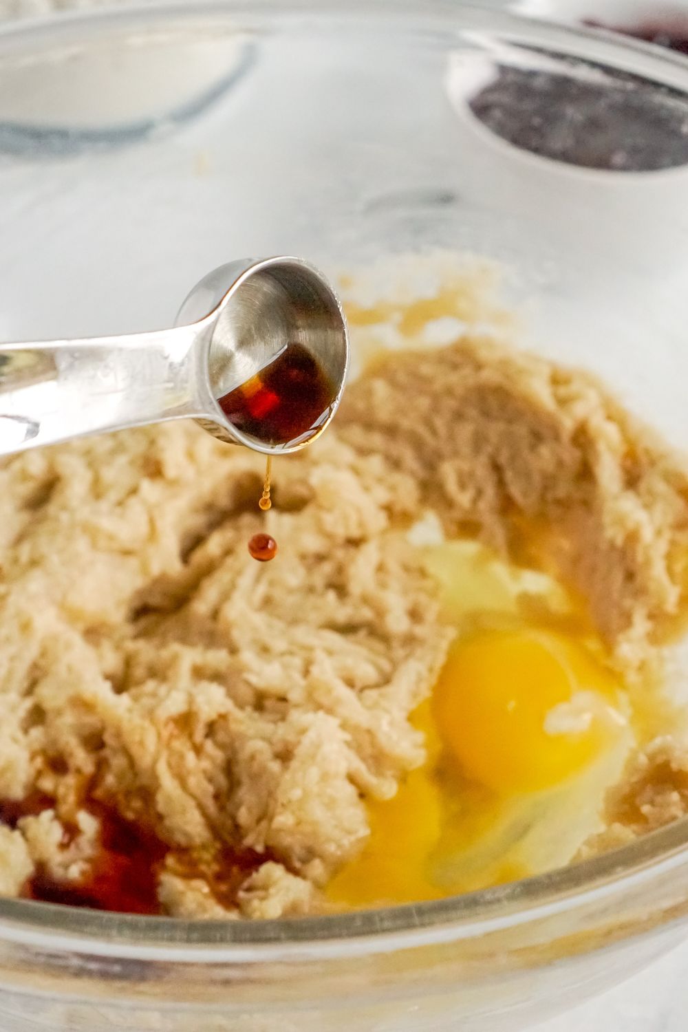 vanilla pouring into a bowl of cookie dough