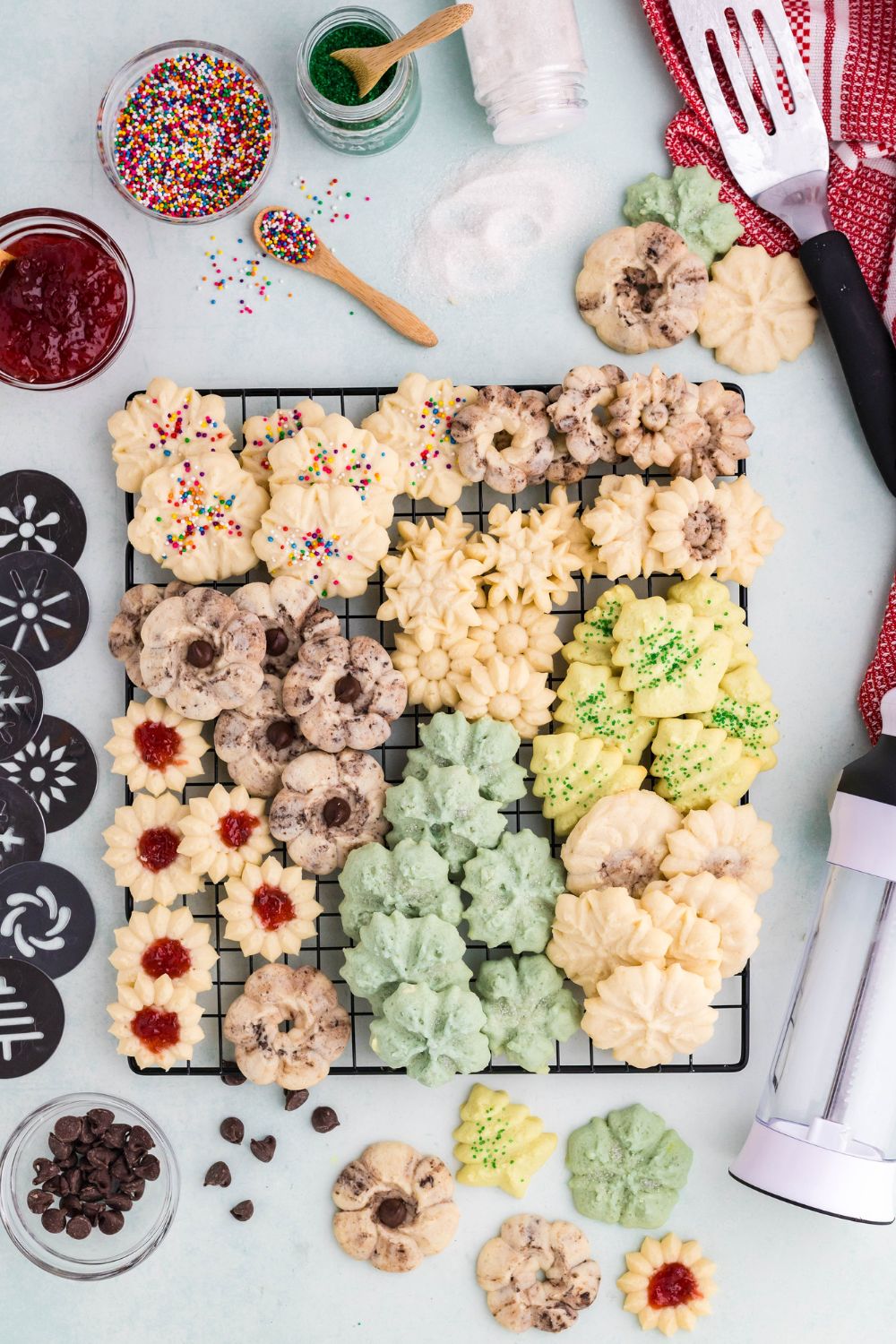 cooling rack full of Spritz Christmas Cookies with the different cookie press shapes