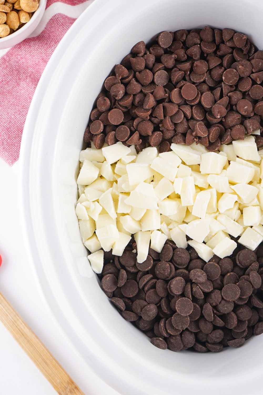 three kinds of chocolate in a slow cooker on table for making Crockpot Christmas Candy