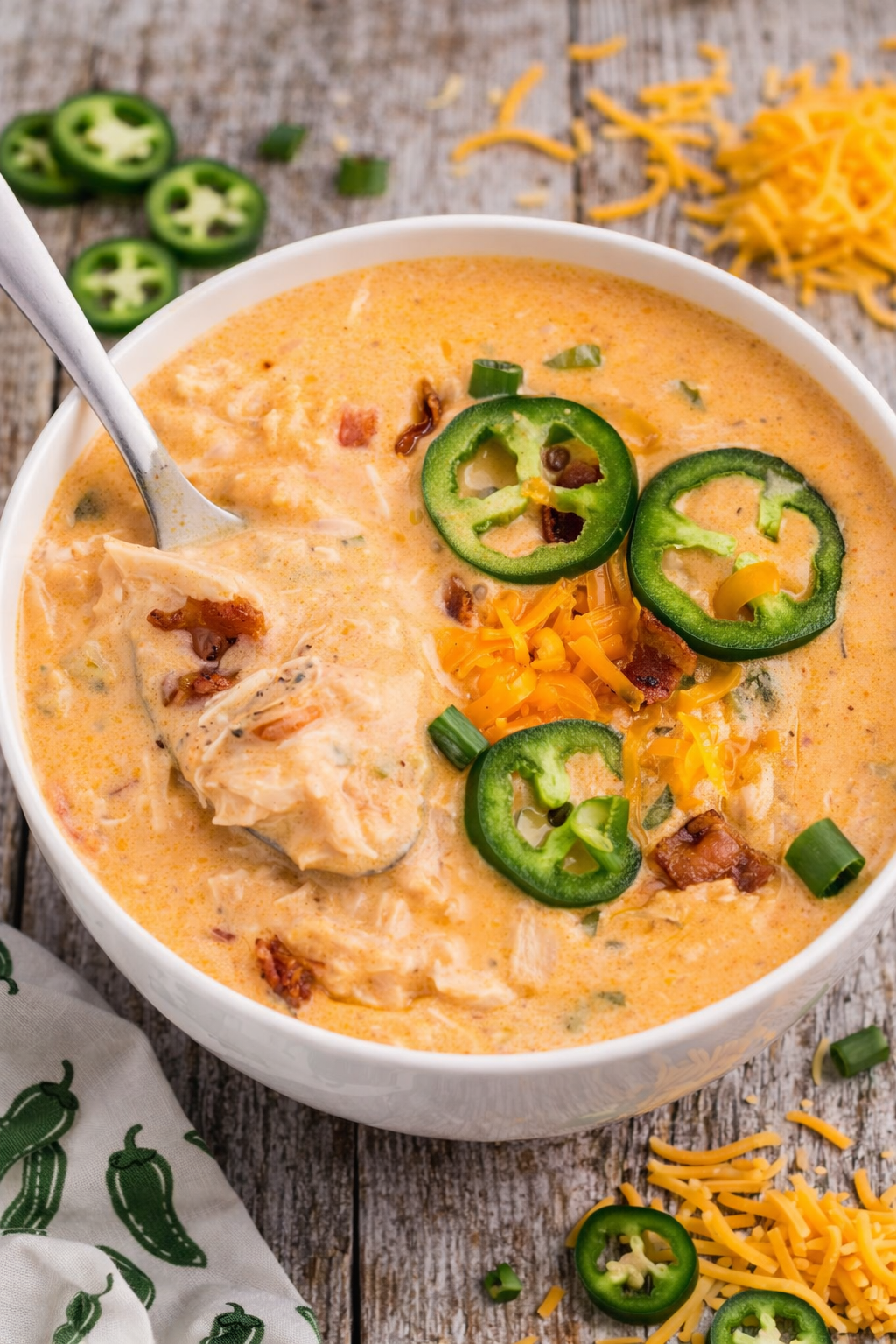 white bowl of jalapeño popper crack chicken soup with jalapenos around the soup