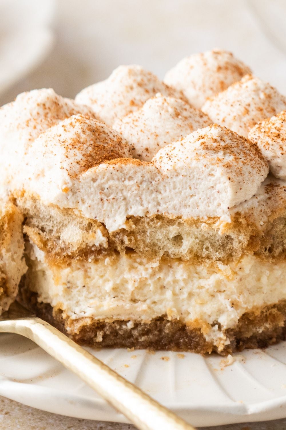 Eggnog Tiramisu on plate with a couple bites taken out of it showing the layers of the dessert 