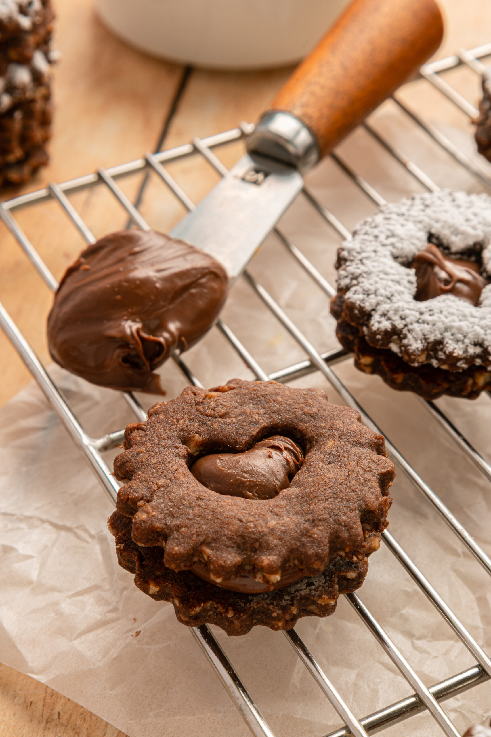 Chocolate Linzer Cookies on a cooling rack without powdered sugar 