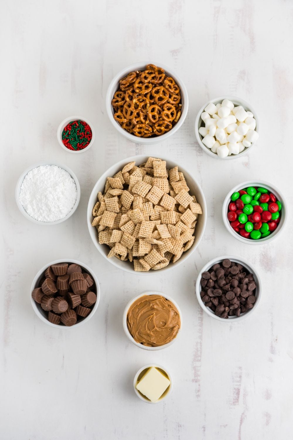 alll ingredients for puppy chow and chex mix in single serve bowls on table