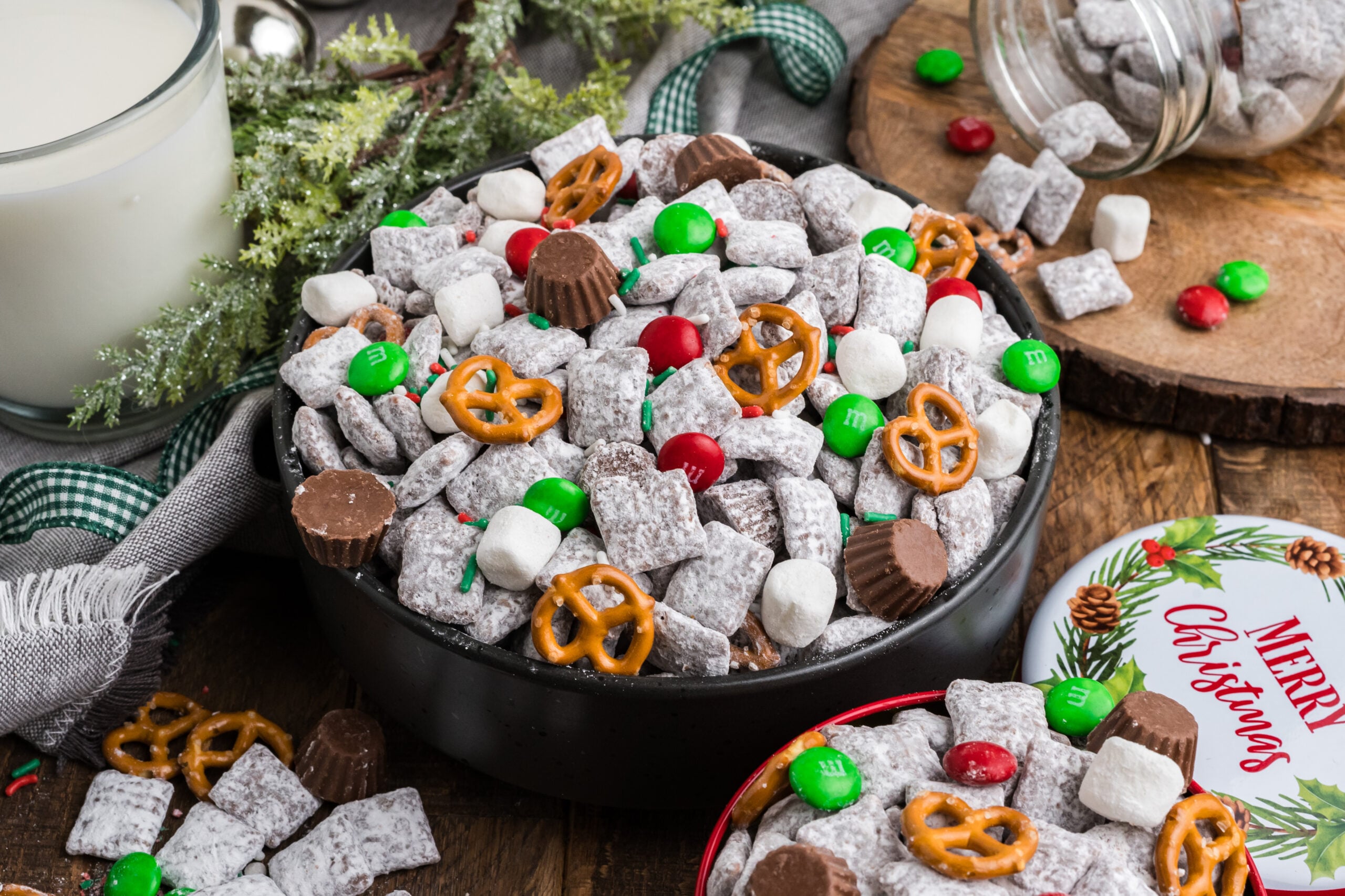 view of a black bowl with Christmas Chex Mix and more puppy chow and toppings falling out of bowl