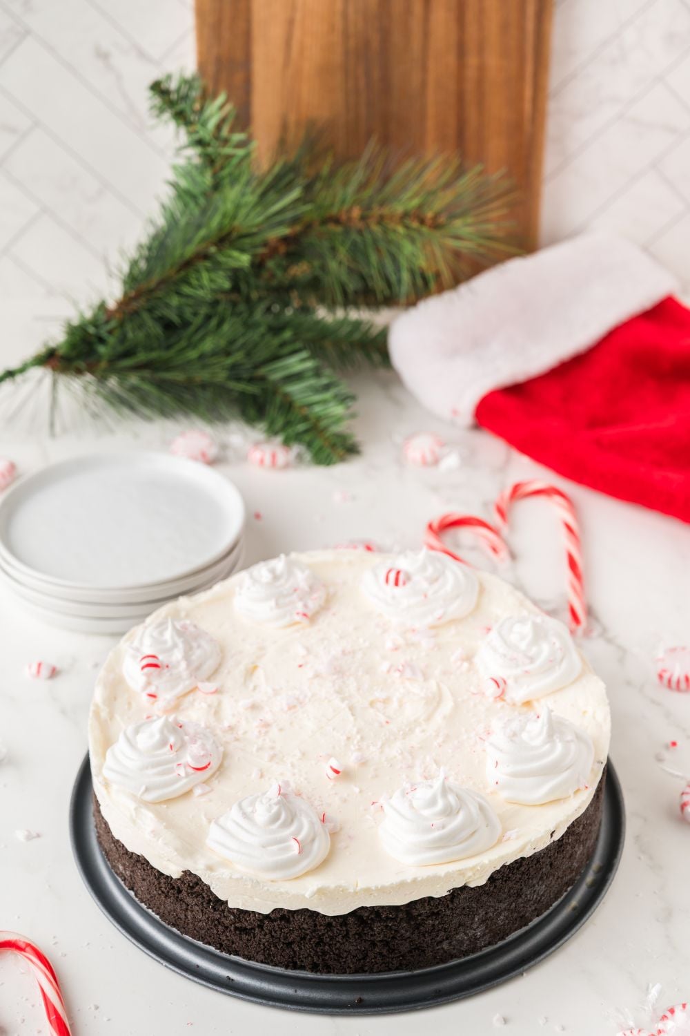 white plate with a plate full of No Bake Peppermint Cheesecake with christmas decora around the table 