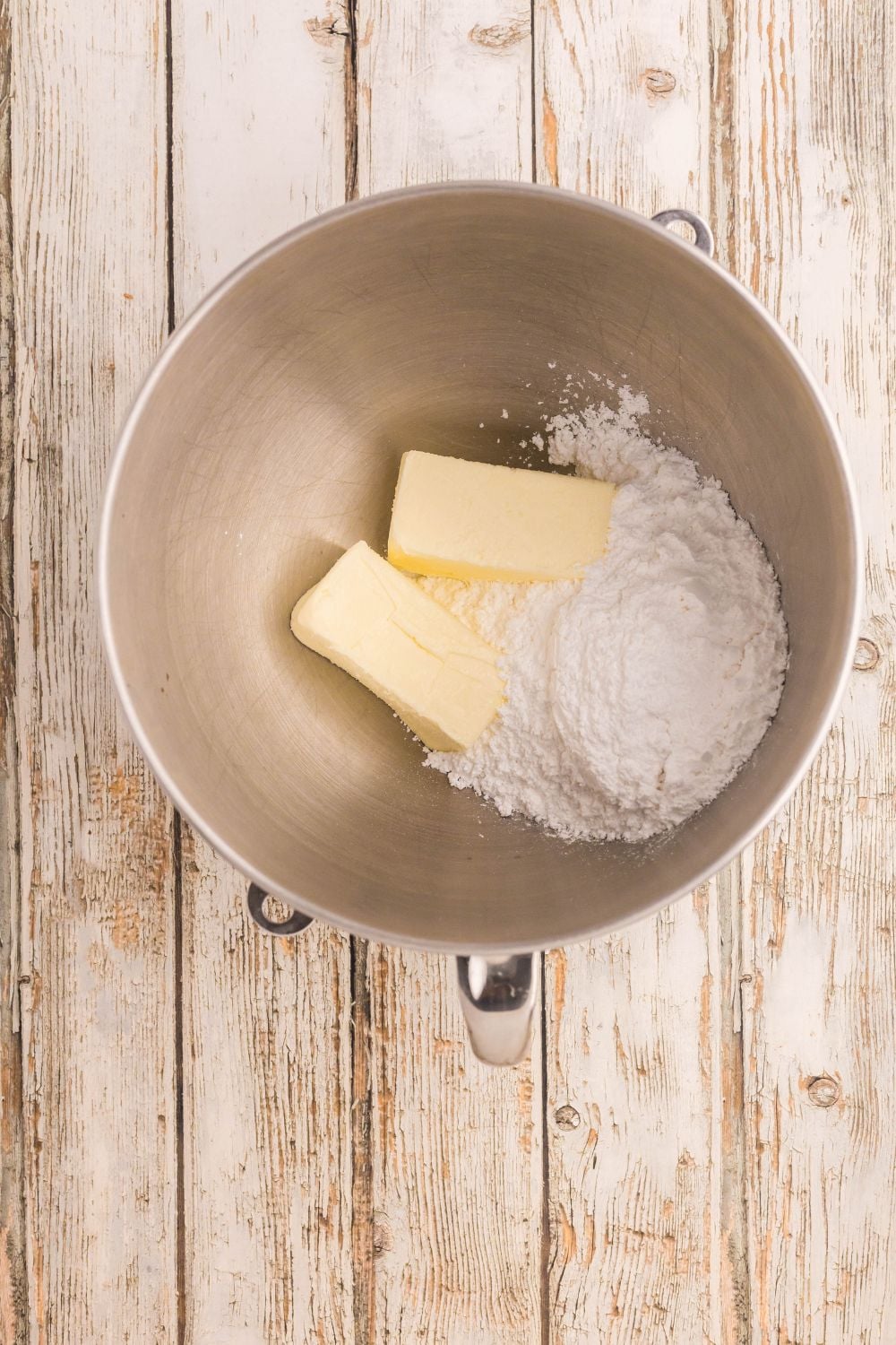 butter and powdered sugar in a metal bowl on table