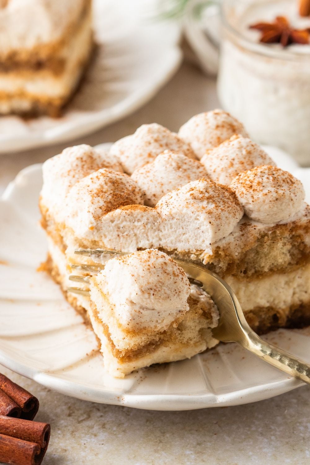 Eggnog Tiramisu on a white plate with a fork slicing into a piece of it 