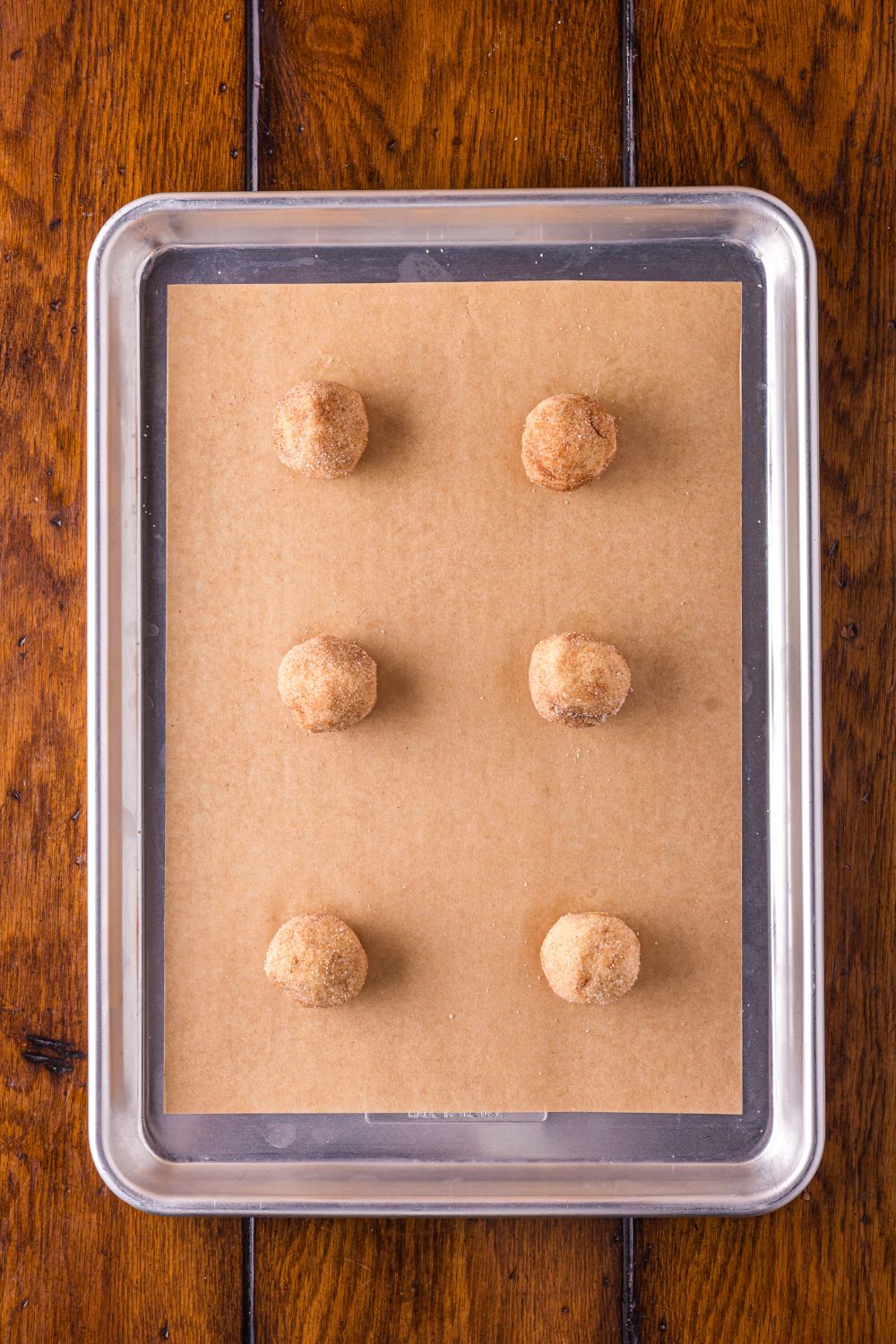 cookie balls for Biscoff Snickerdoodle Cookies on a baking sheet pan