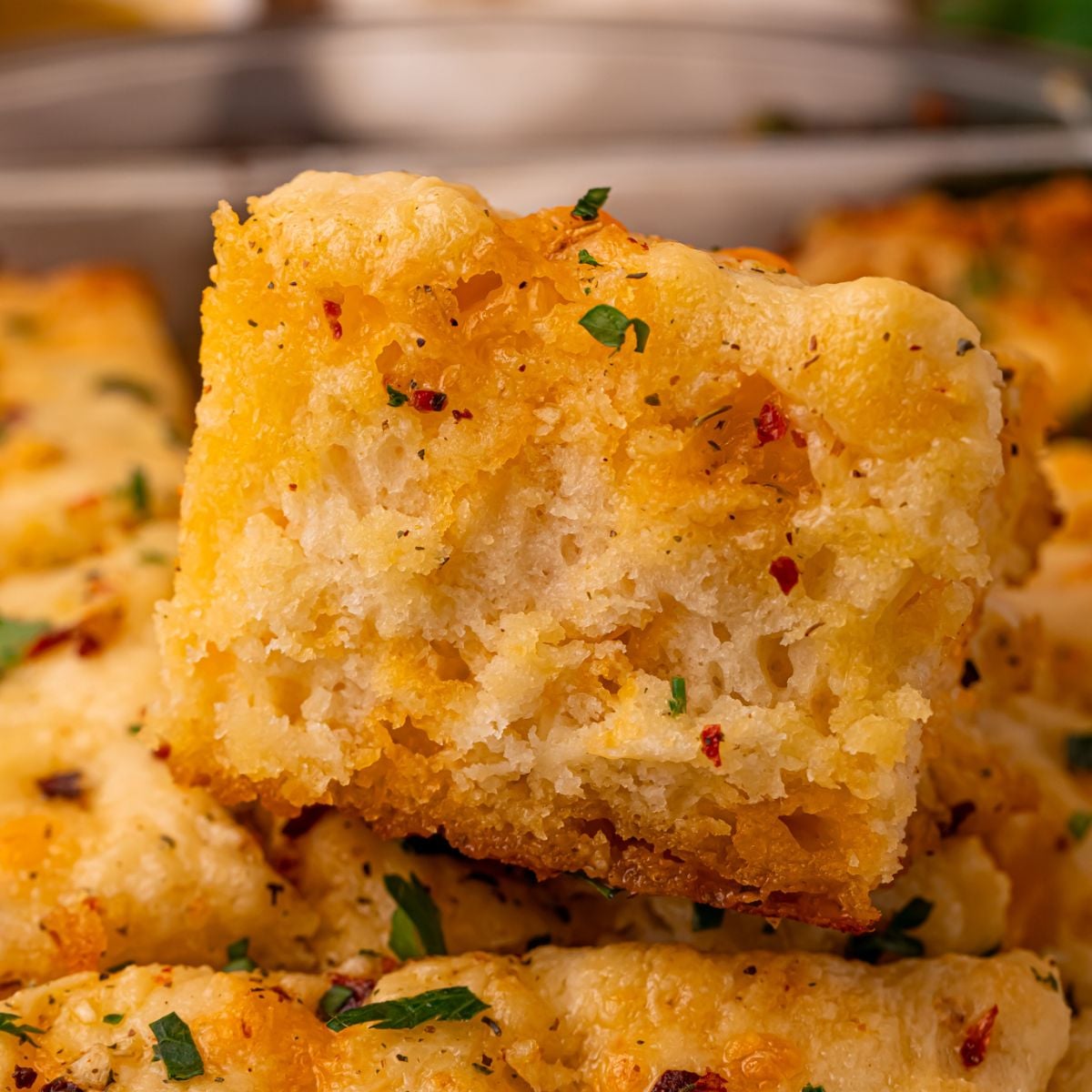 Cowboy Butter Swim Biscuits in a glass pan on table with one close up on the biscuit