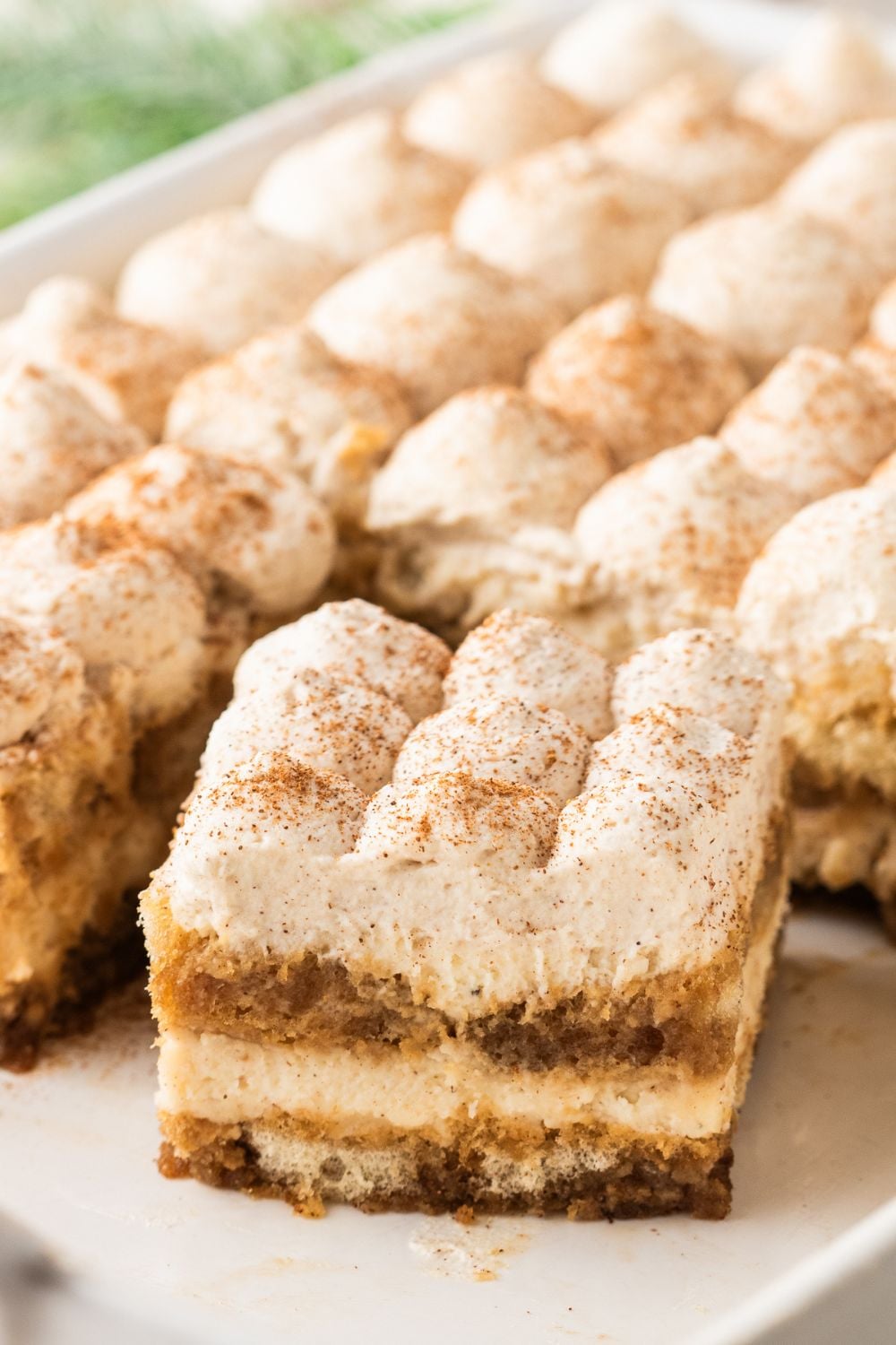 Eggnog Tiramisu in a casserole pan with one slice turned sideways 