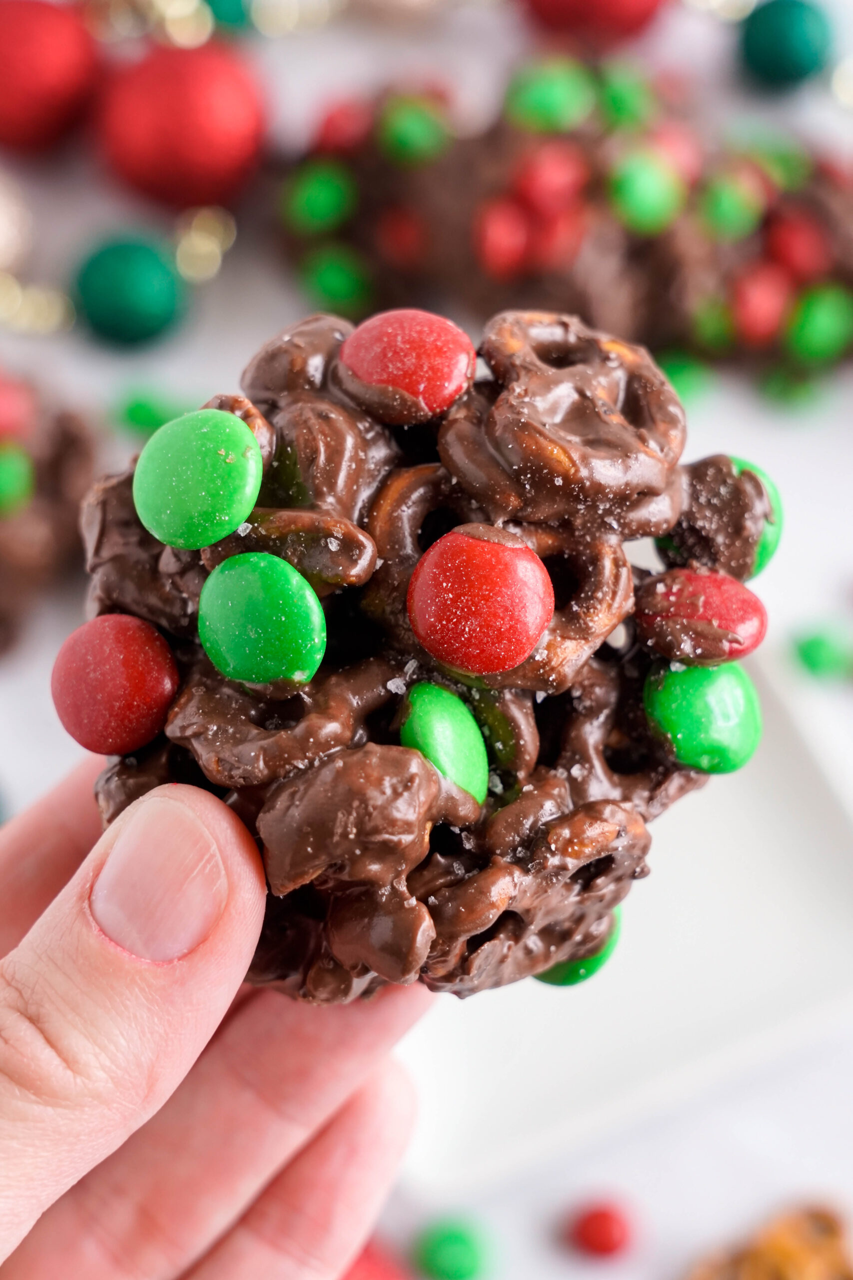 Crockpot Chocolate Pretzel Christmas Candy piece being held up