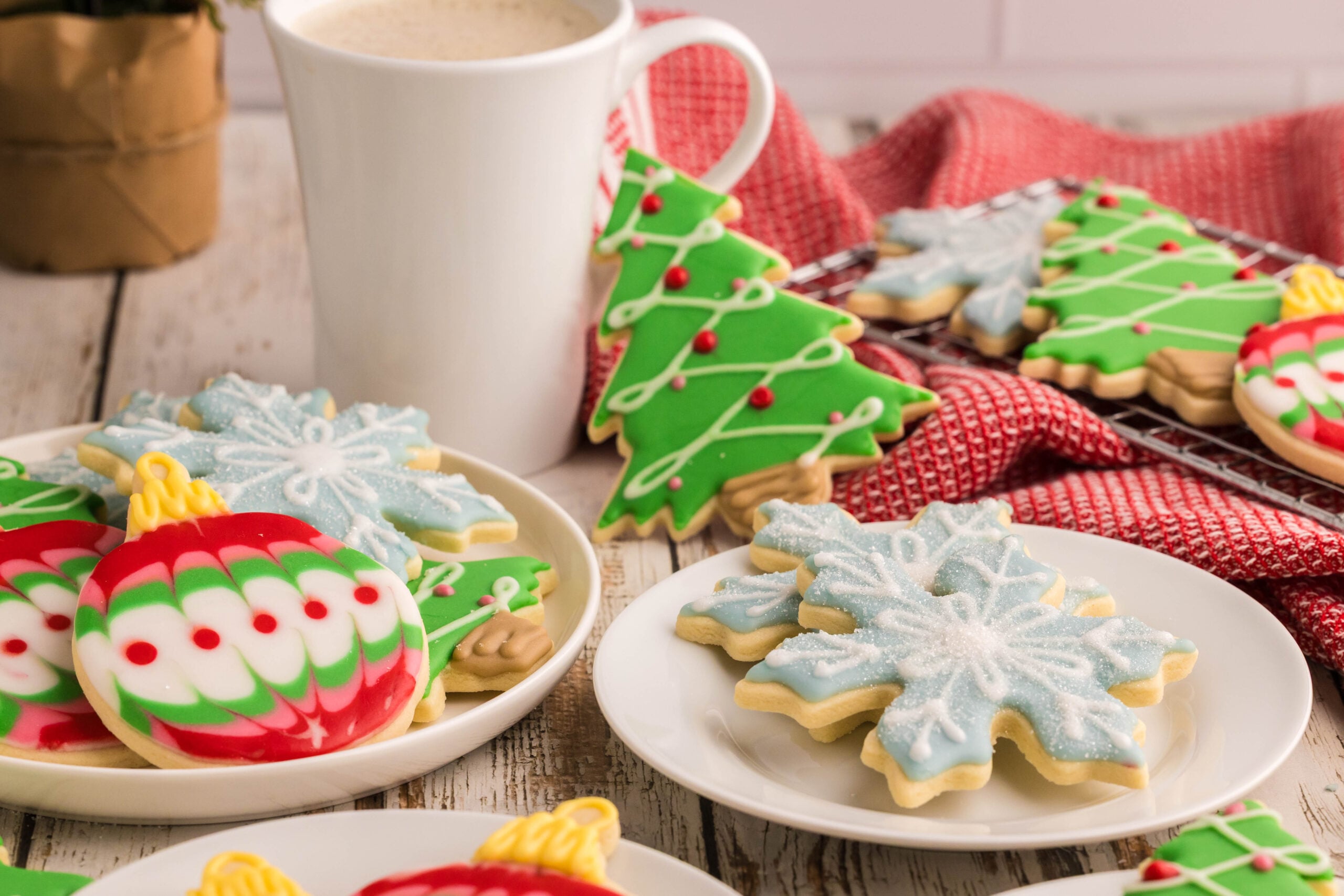 white plate of Christmas sugar cookies with royal icing decorating them