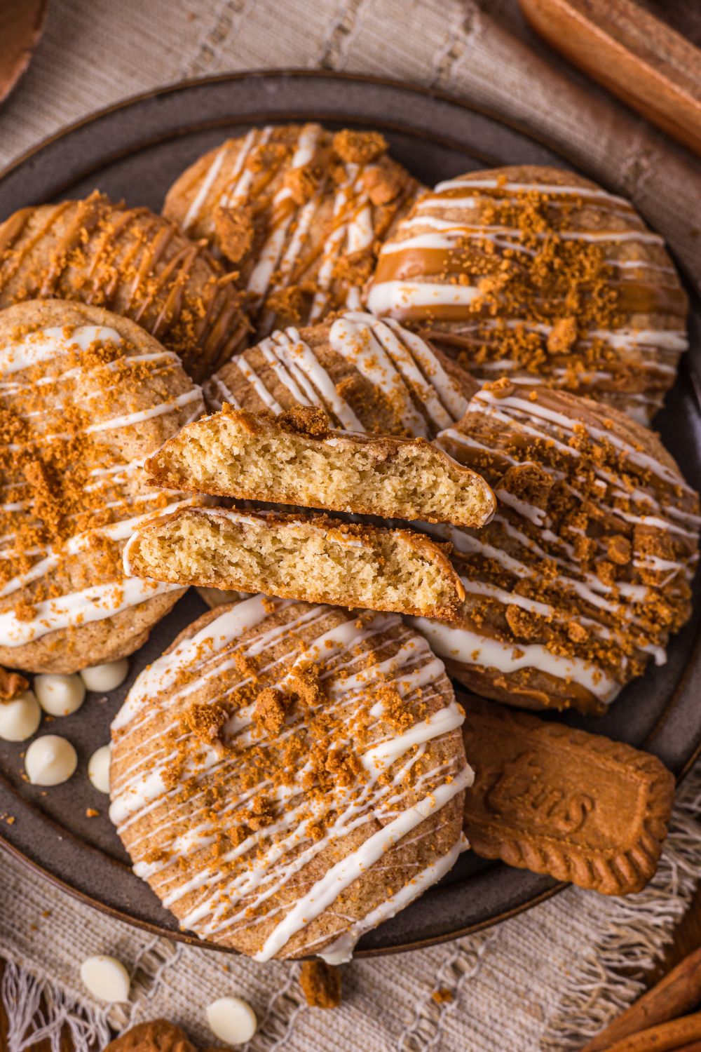 Biscoff Snickerdoodle Cookies on a round plate on table with Biscoff cookies, white chocolate, and more around the tray