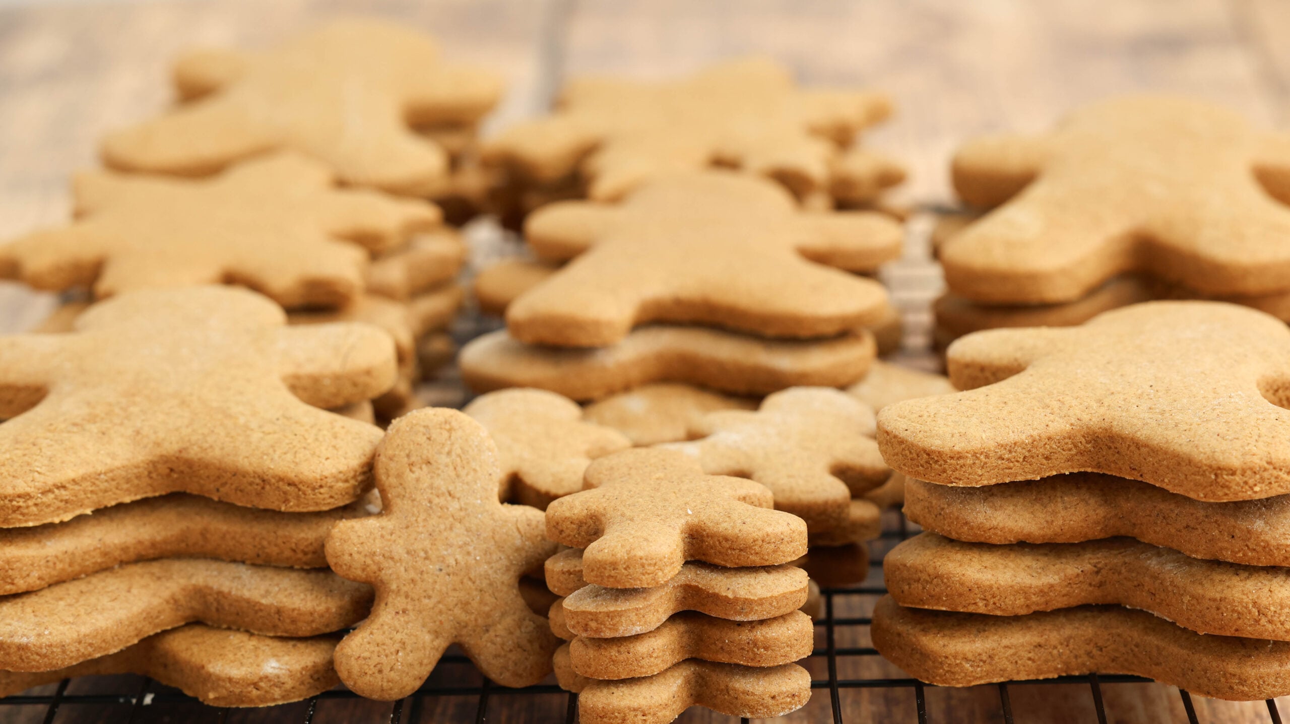 Cooling rack filled with stacked Christmas gingerbread cookies waiting to be decorated 