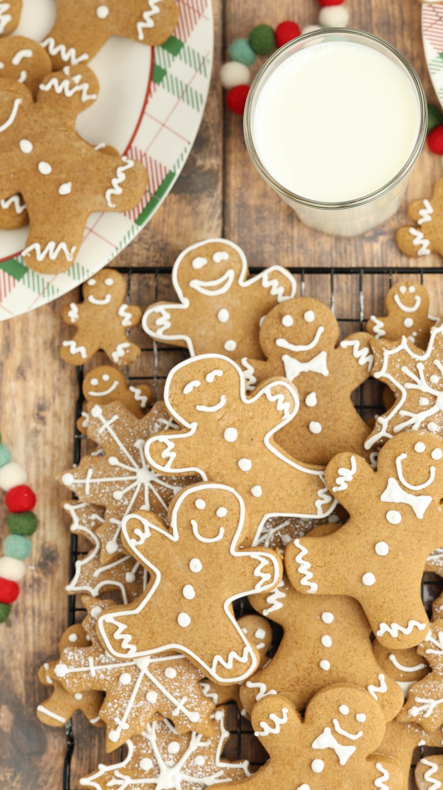 overhead shot of a cooling rack with Christmas gingerbread cookies and a big cup of milk