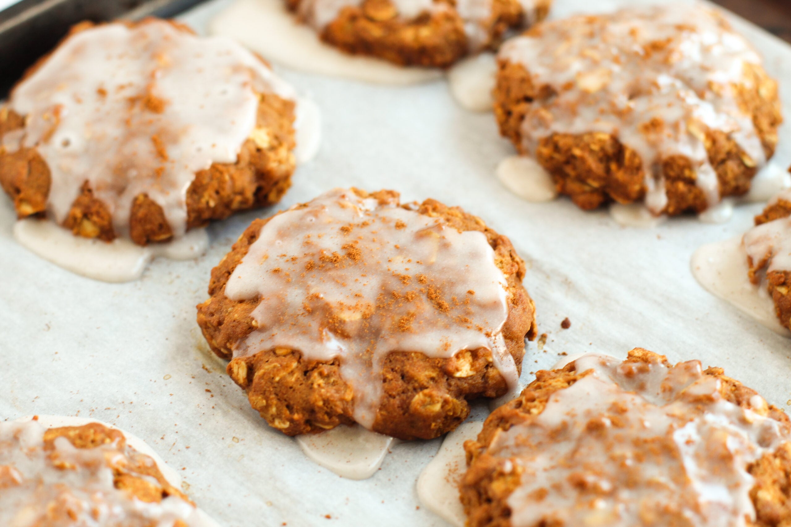 Iced Gingerbread Oatmeal Cookies on baking sheet baked and iced