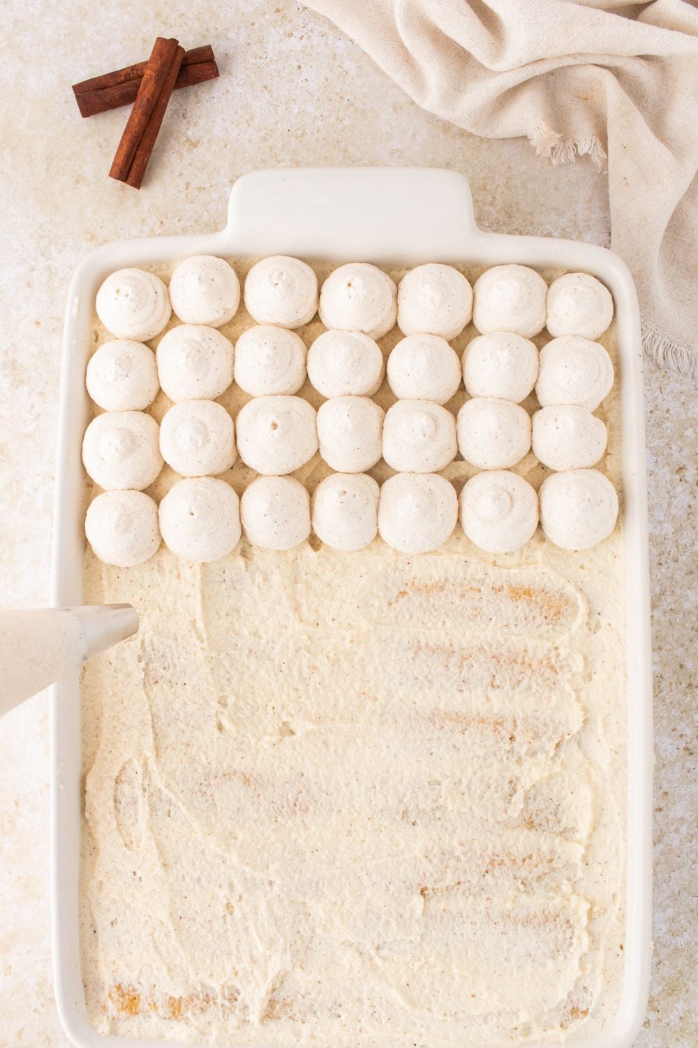 piping topping on top of the Eggnog Tiramisu